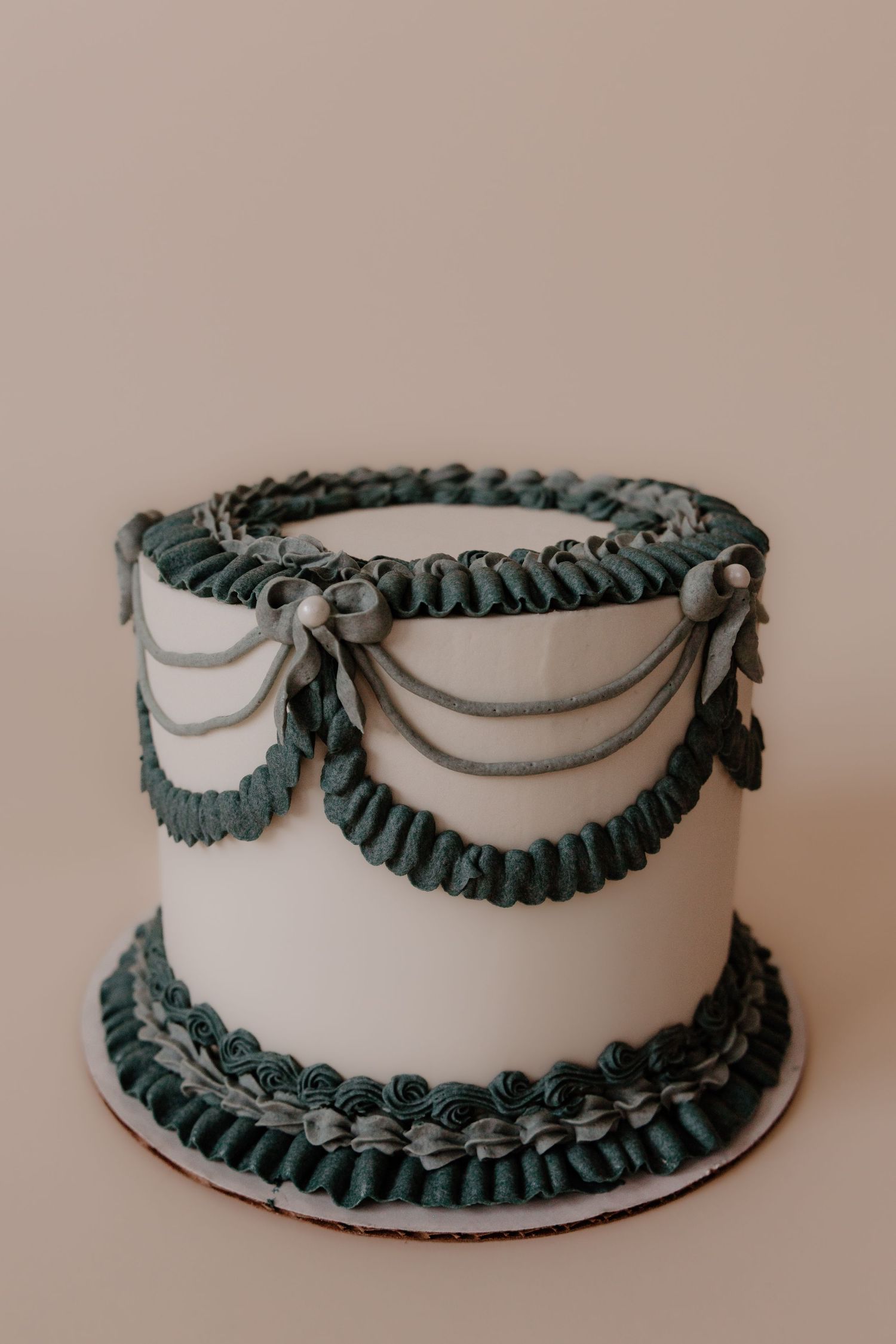 White cake with elegant teal ruffle trim decoration shown from multiple angles.