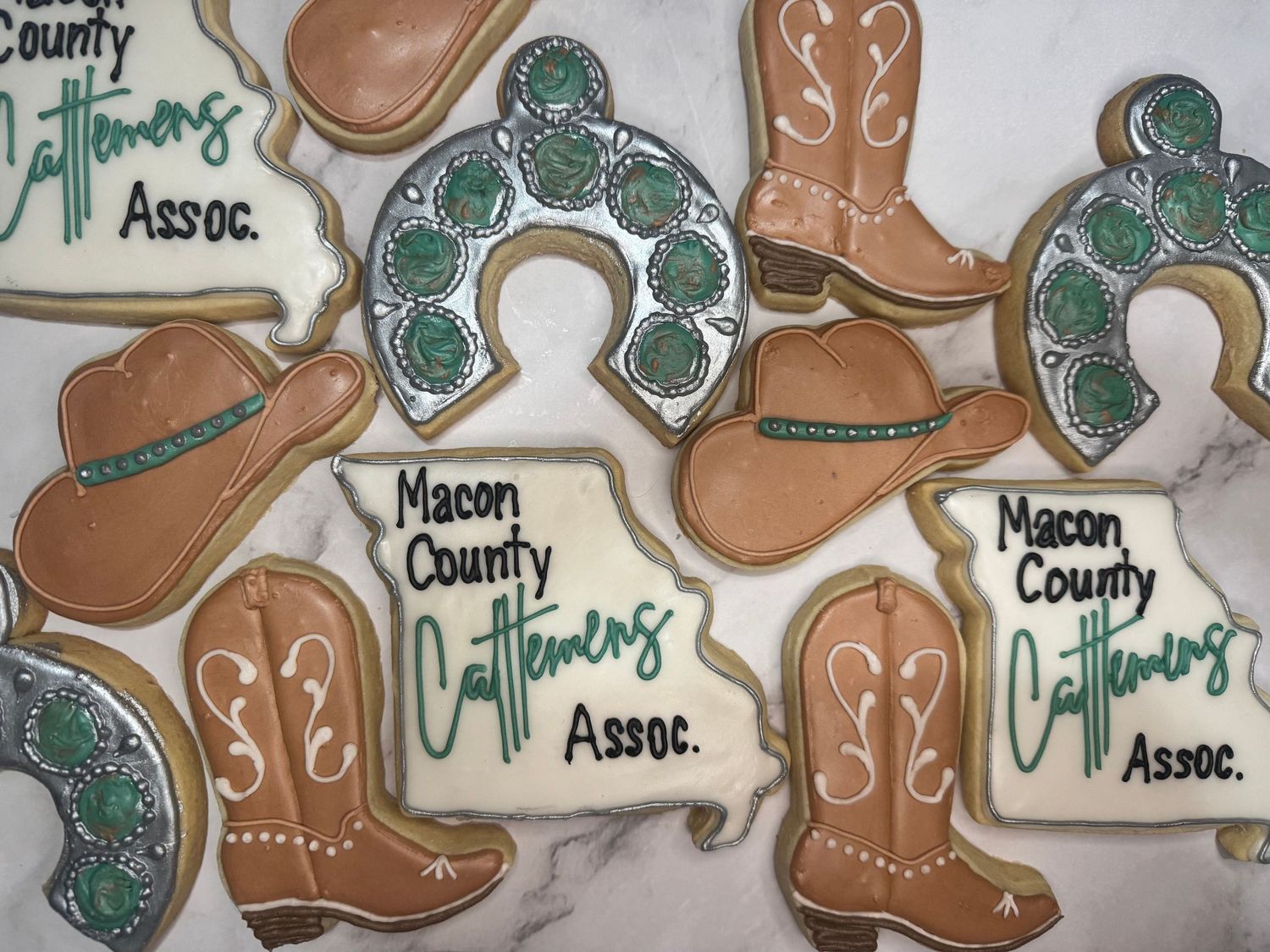 Decorative cowboy boots cookies with teal and brown icing designs and detailed embroidery patterns.