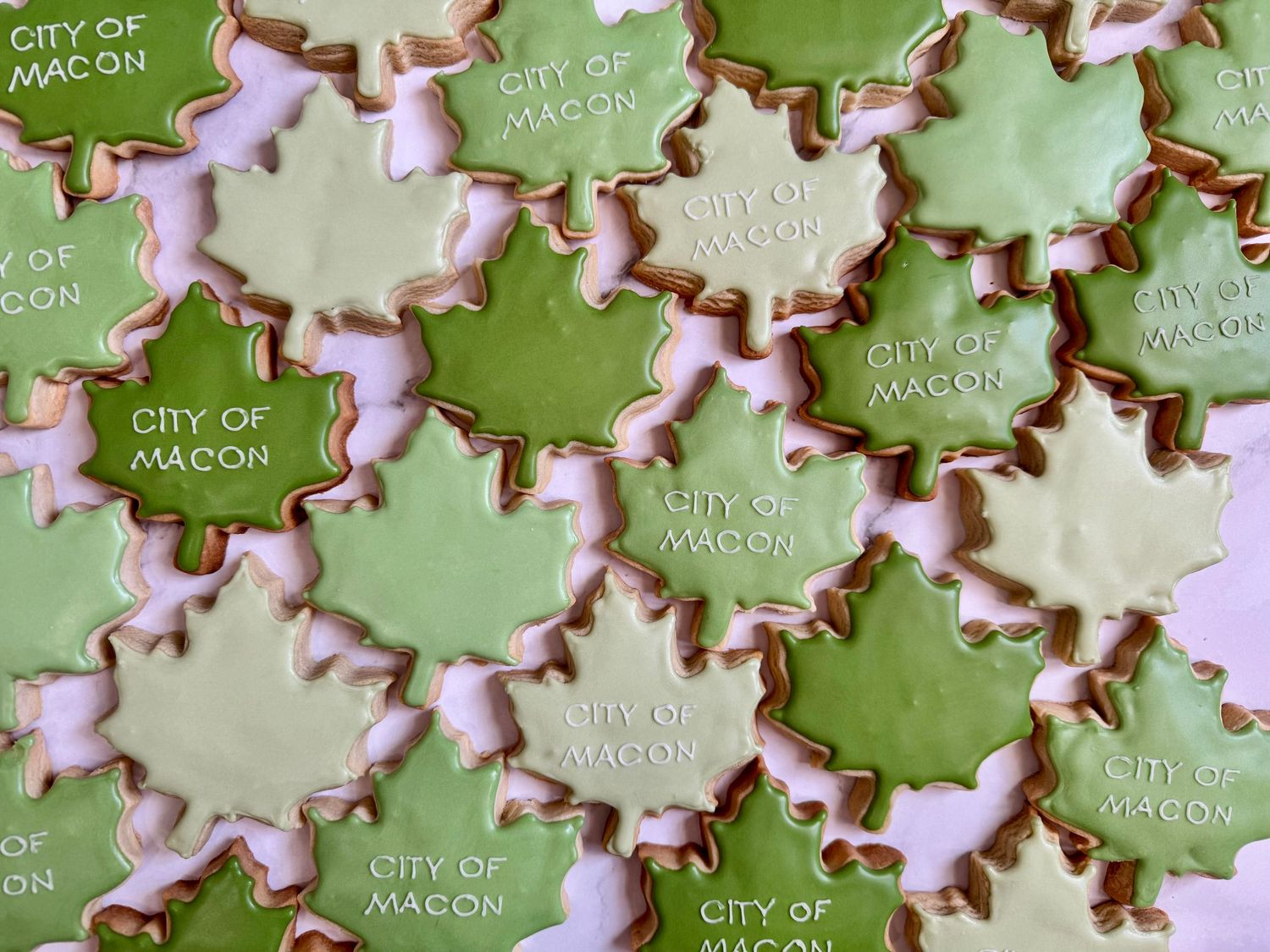 Custom sugar cookies decorated in green with City of Macon text and border details.