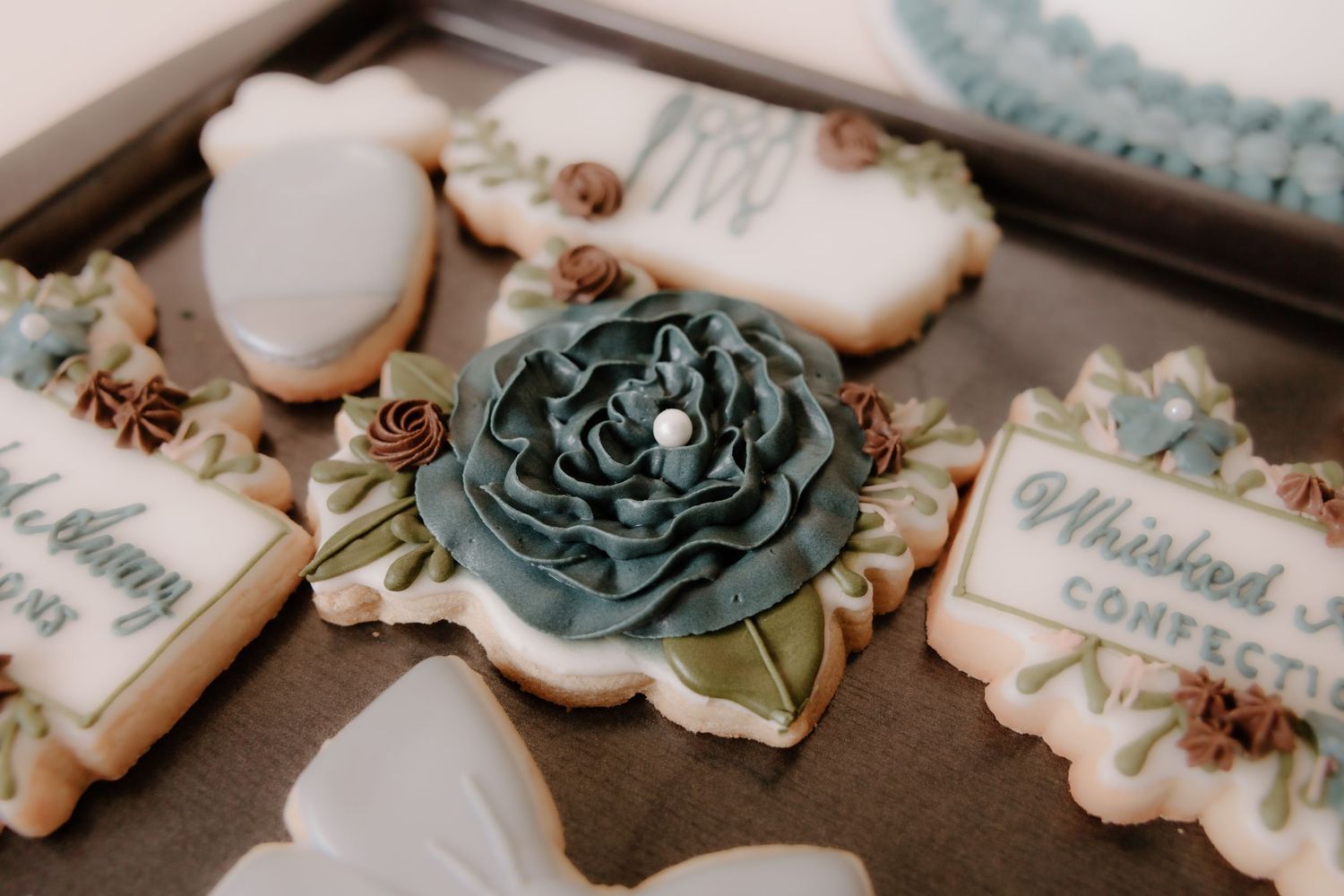 Elegant wedding cookies with blue floral designs and delicate piping details.