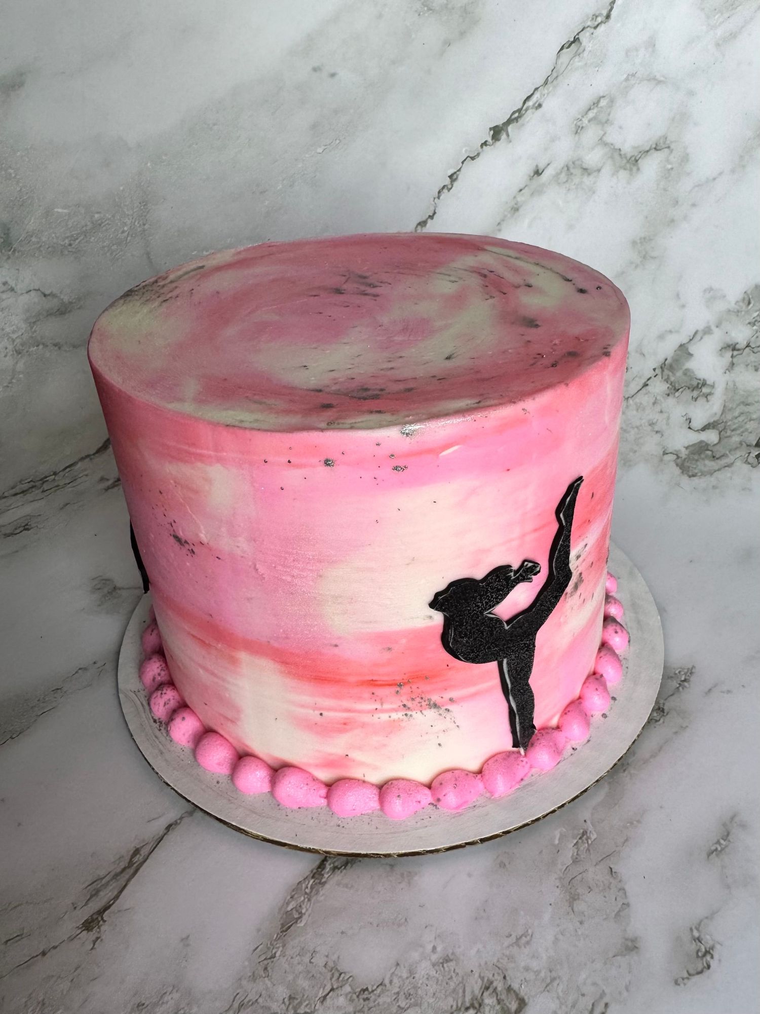 Pink ballet-themed cake featuring a dancer silhouette and delicate piped border.