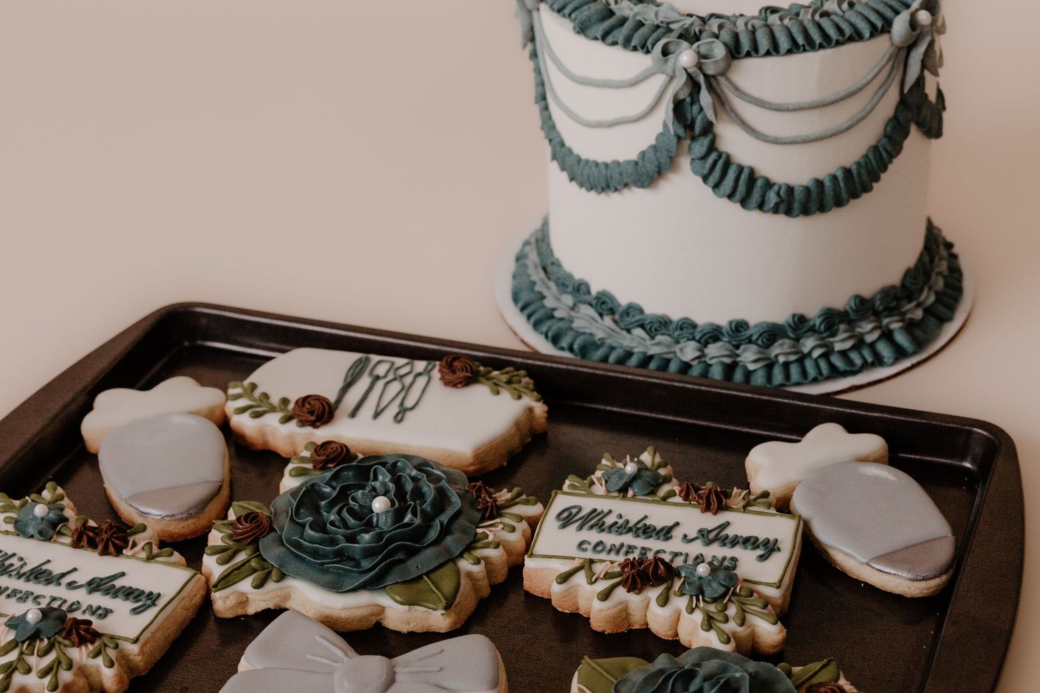 Decorated sugar cookies with teal and white royal icing in an elegant wedding design.