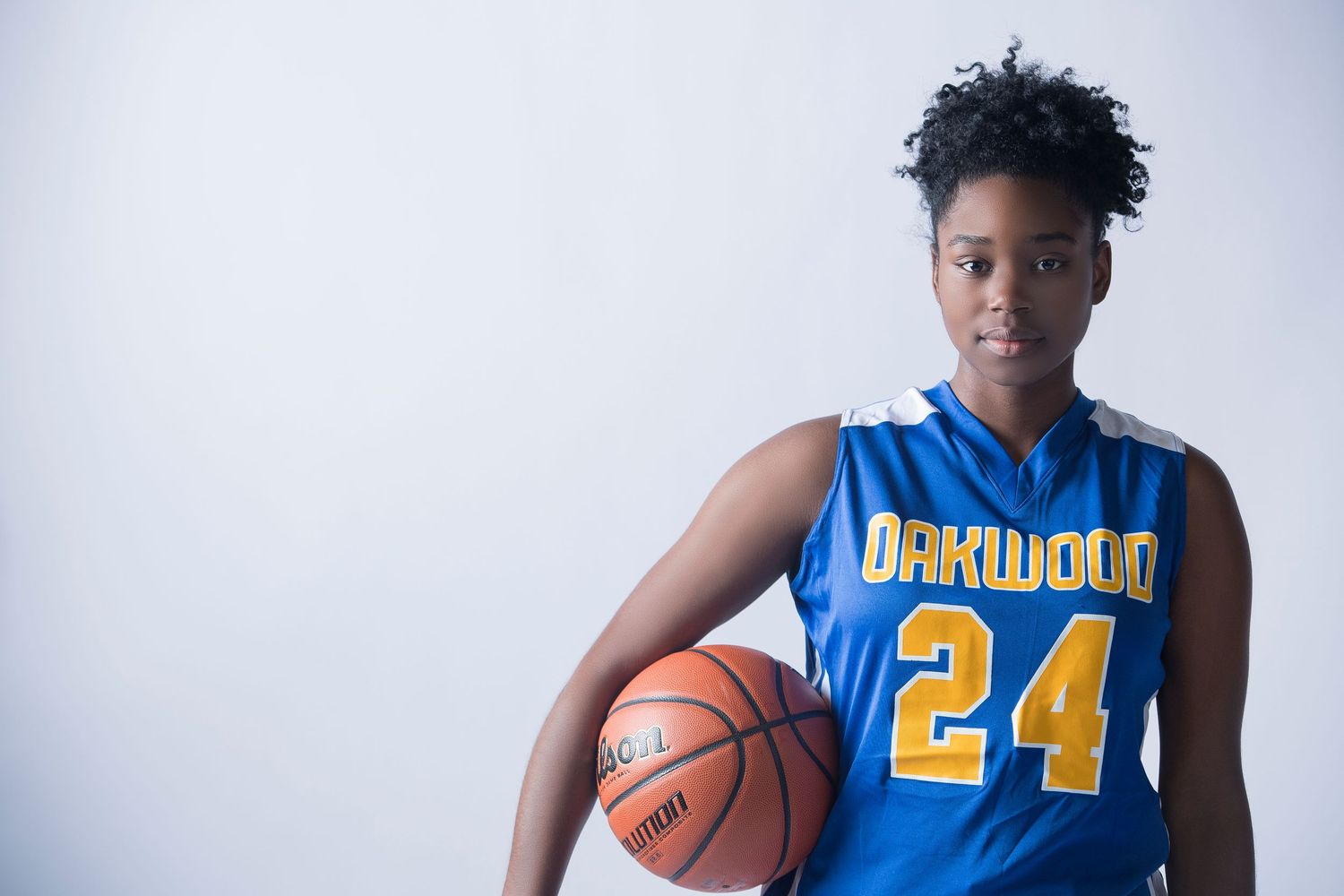 Basketball players in blue and white uniforms stand in athletic poses.