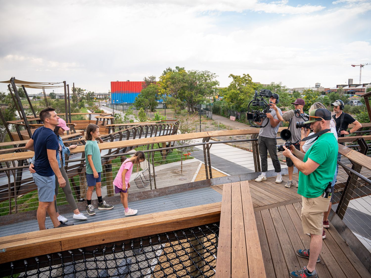 People gathered on wooden observation deck overlooking scenic landscape.