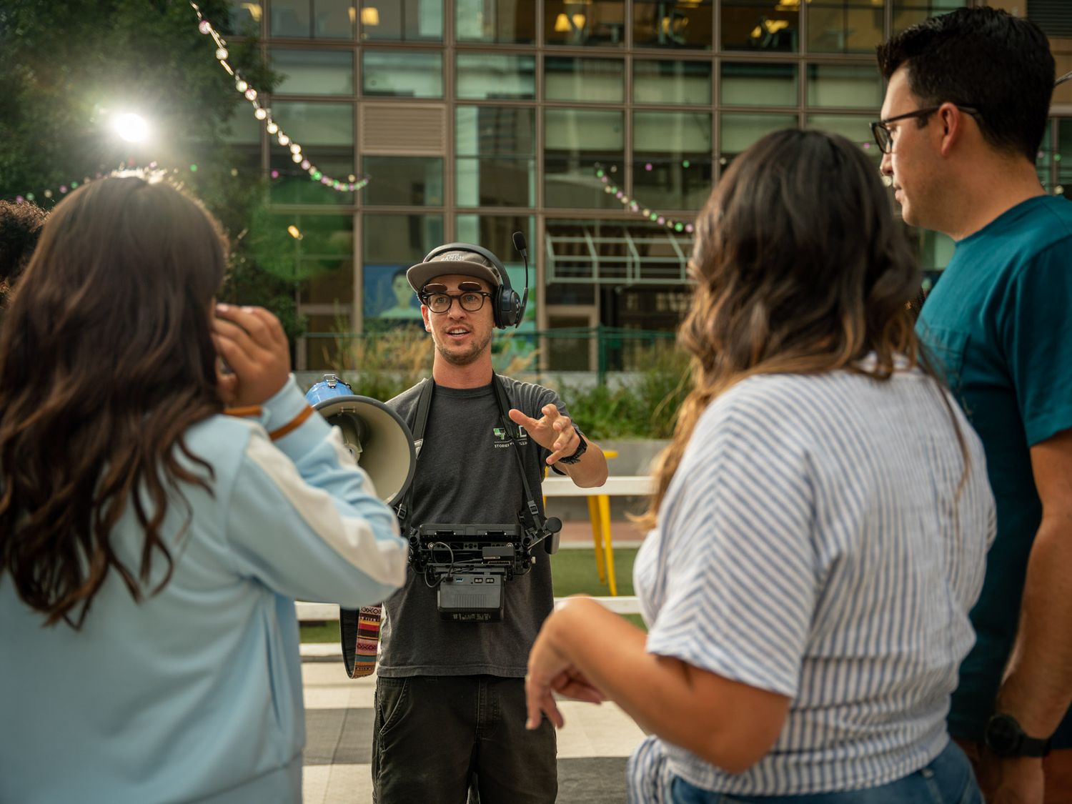 Group of people gathered outdoors at dusk having a casual conversation.