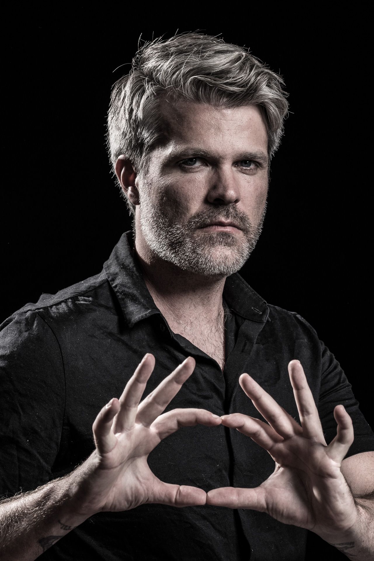 Dramatic portrait series against black background with expressive hand gestures.