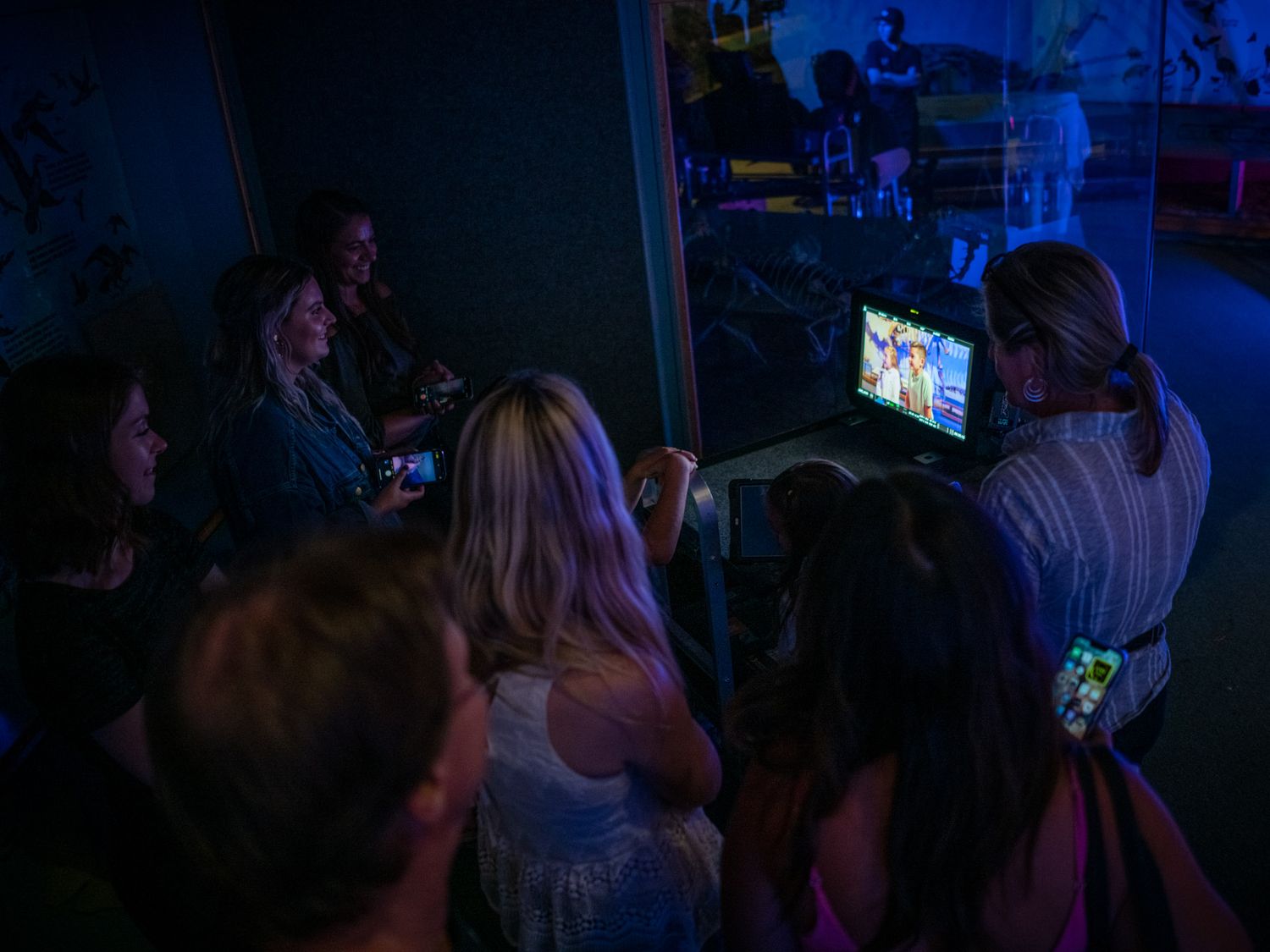 Dark silhouettes of audience members watching a presentation or performance.