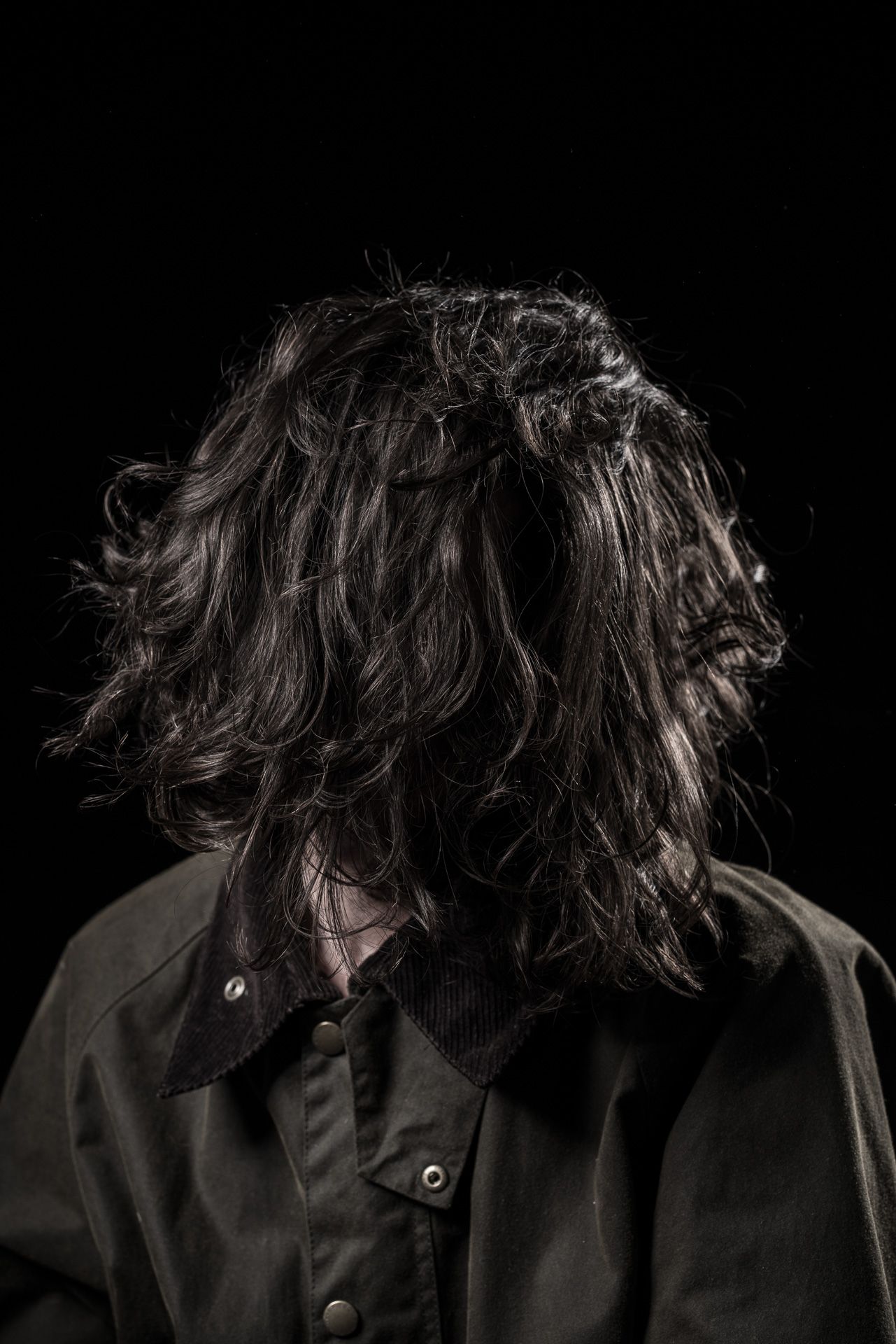 Dramatic series of dark silhouettes showing long hair against black background.