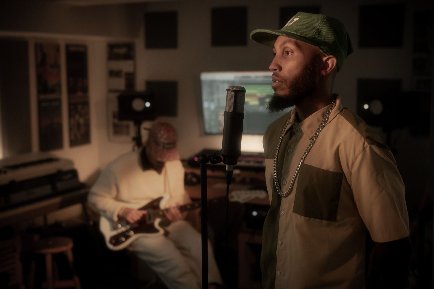Musicians performing in a dimly lit studio space with recording equipment.