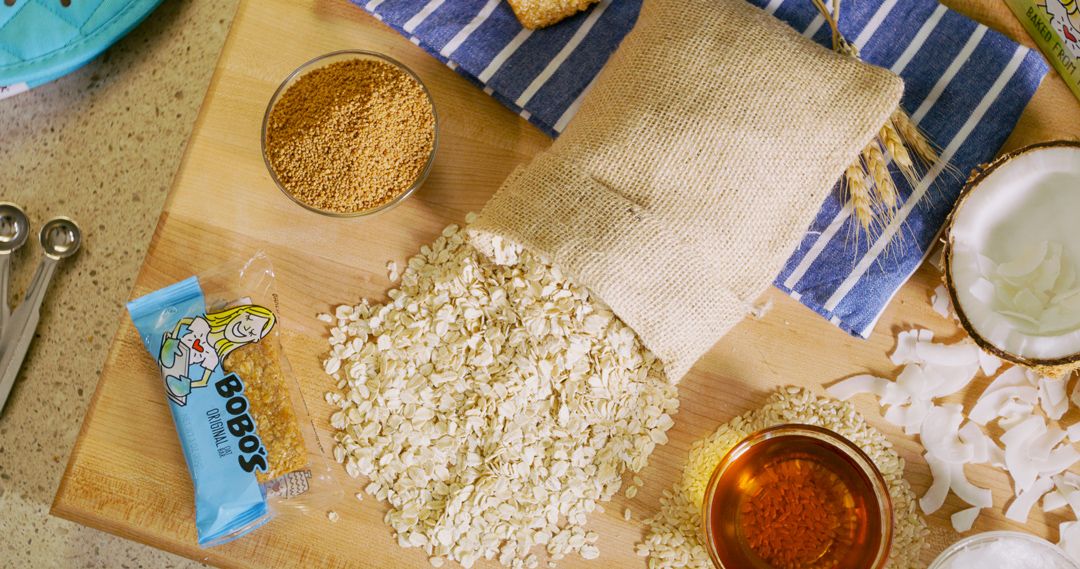 Blue measuring tools and baking ingredients laid out on a wooden countertop.