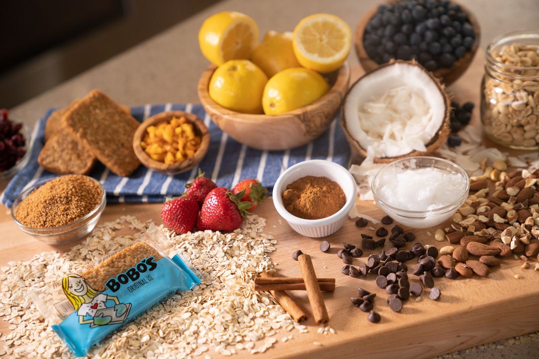 Colorful baking ingredients including lemons, berries, and spices on a wooden surface.