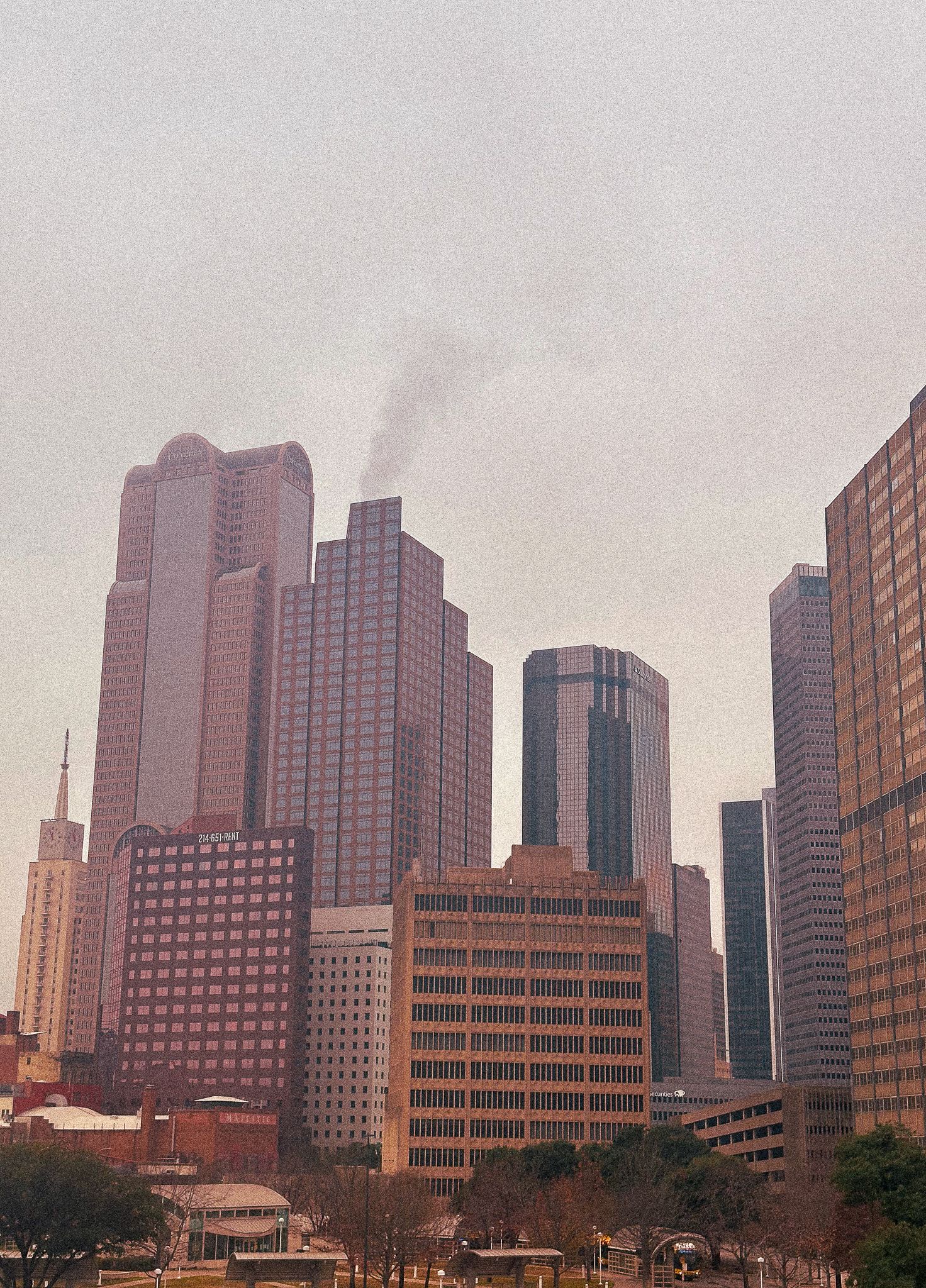 Boston skyline panorama with skyscrapers and office buildings against a cloudy sky at dusk.