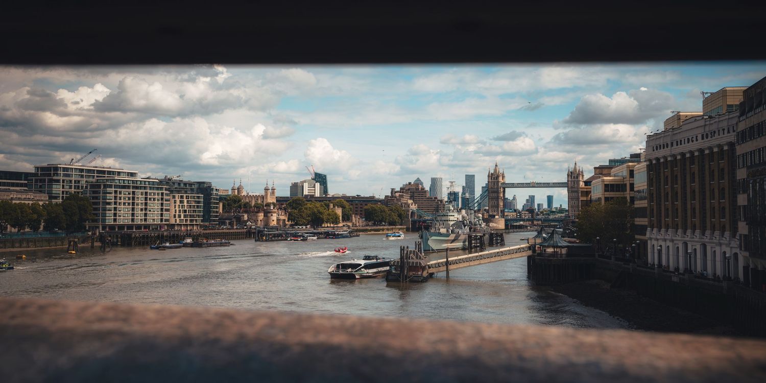View of the River Thames and Tower Bridge in London, England, taken from London Bridge, featuring boats and the city skyline.