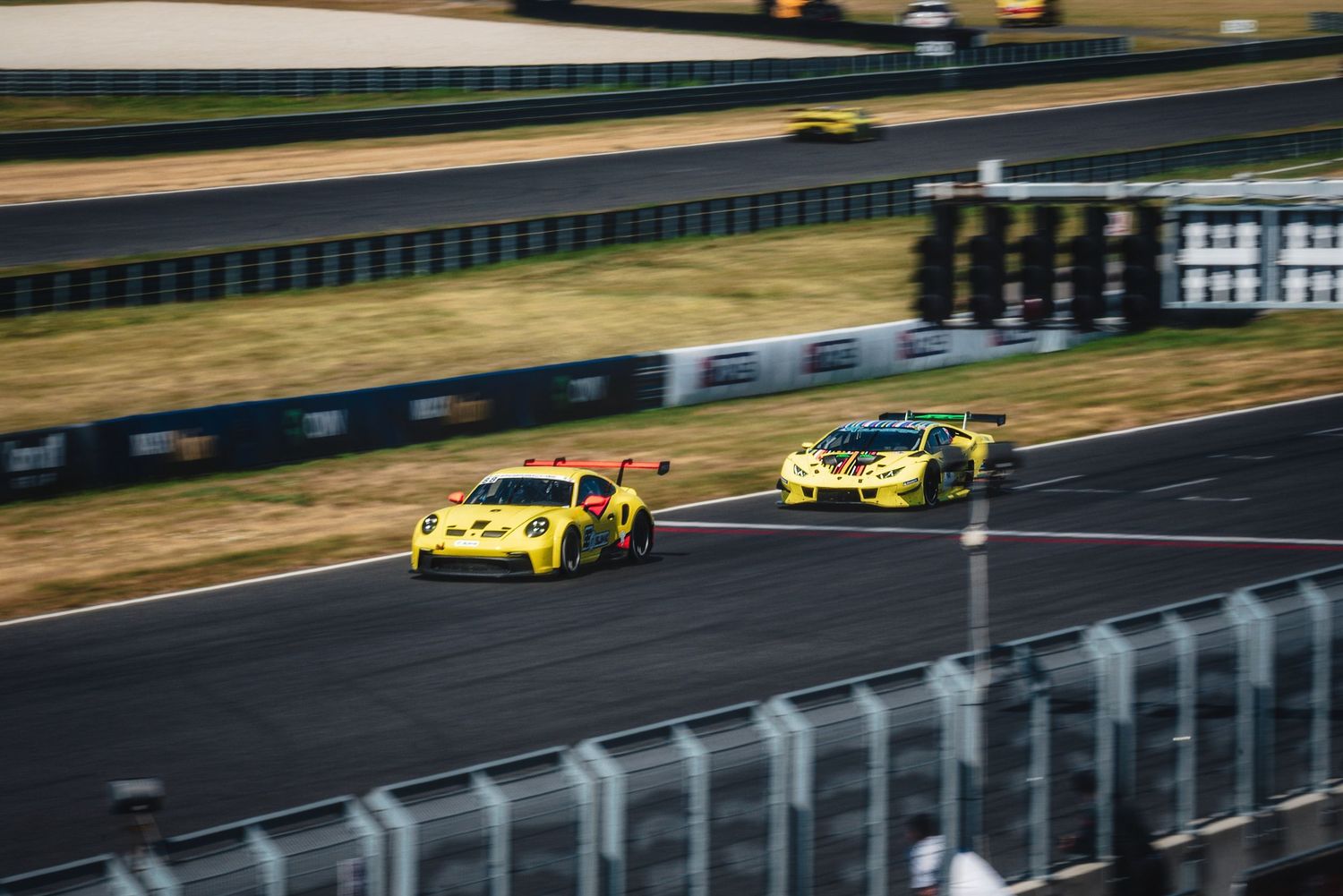 GT3 race cars racing down the main straight at the Slovakia Ring circuit during the GT Series event in Orechová Potôň, Slovakia.