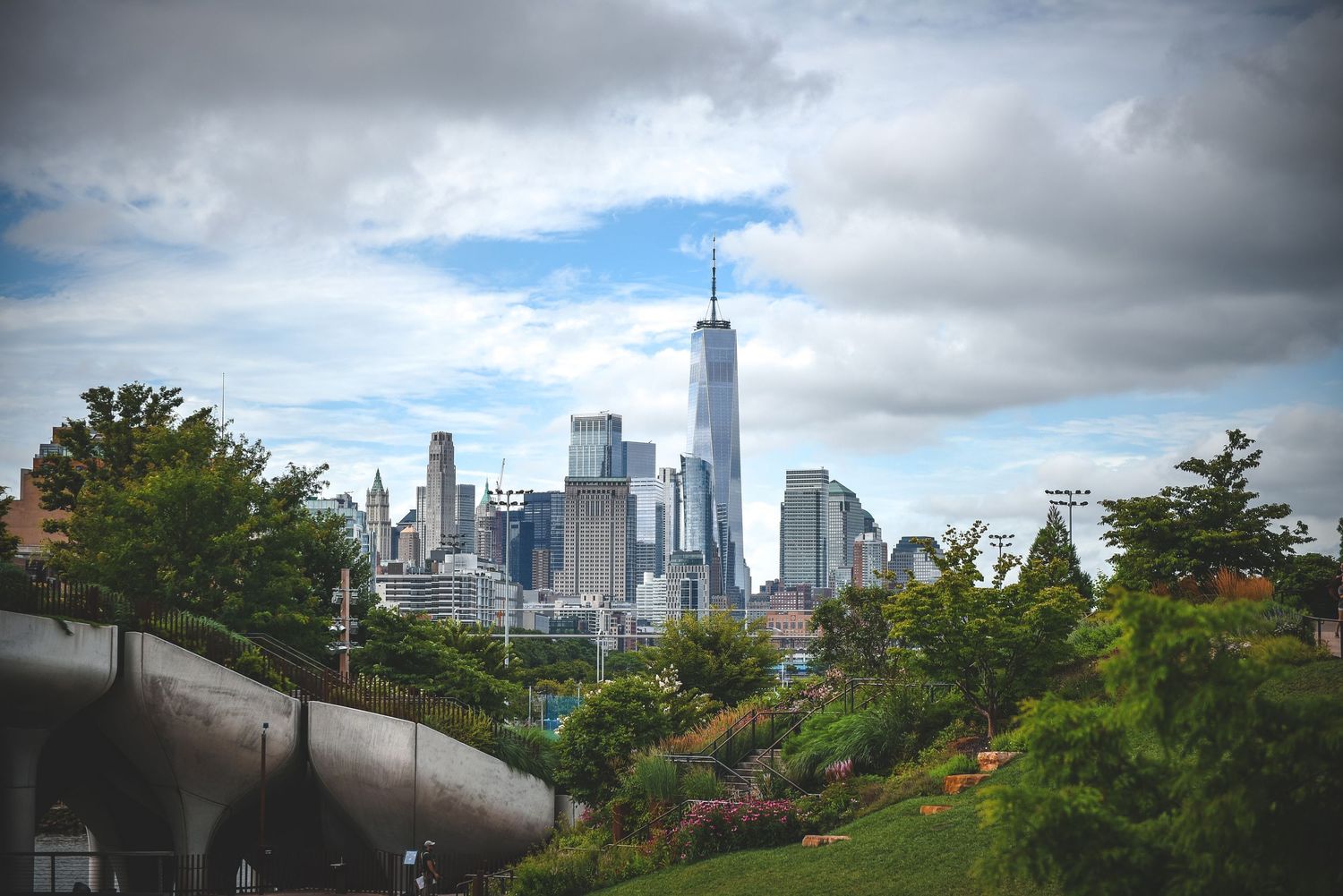 Lower Manhattan skyline featuring One World Trade Center, viewed from the elevated green spaces of Little Island in New York City.