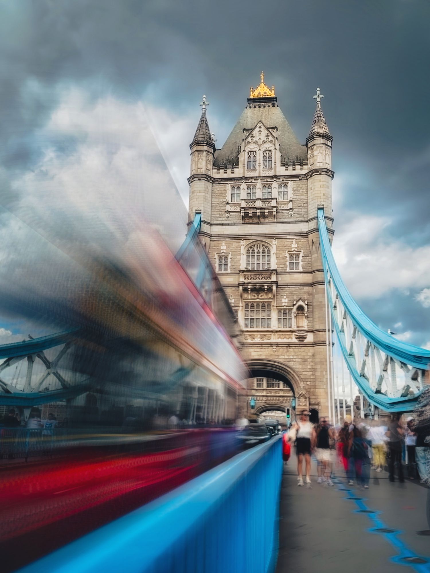 Tower Bridge in London, England, with a blurred red double-decker bus moving across the bridge in the foreground