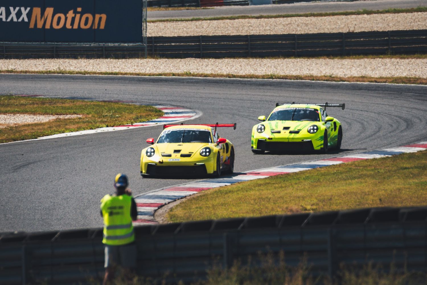 Porsche 911 GT3 Cup race cars rounding a bend on the track at Slovakia Ring circuit in Orechová Potôň, Slovakia.