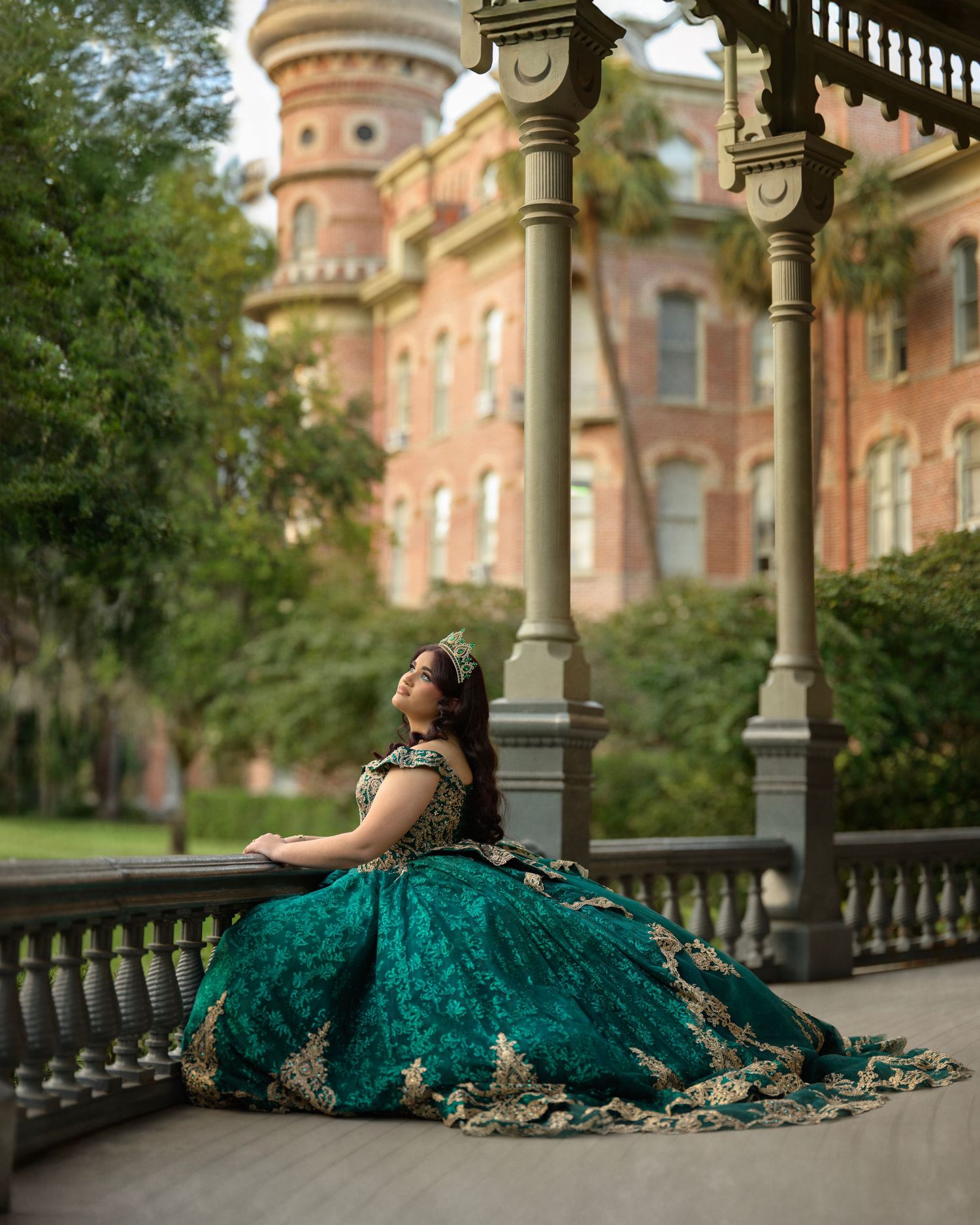 Elegant emerald ballgown dress photographed at historic building with ornate architecture.