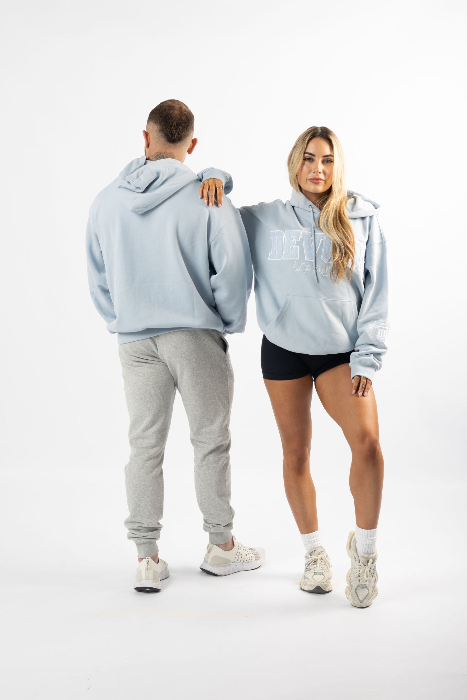Models wearing matching light blue hoodies and sweatpants showcase casual athleisure outfits from different angles.