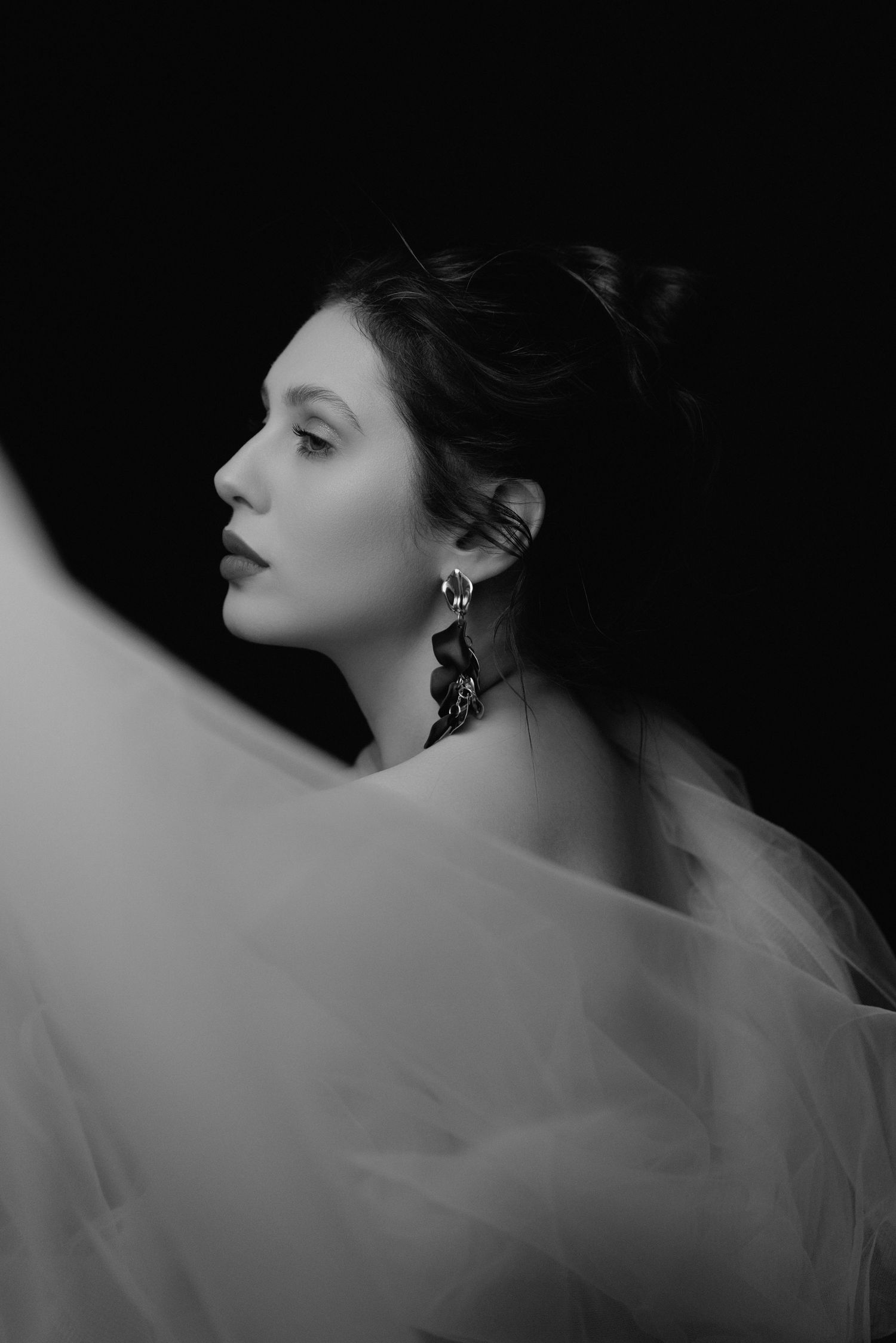 Artistic profile shots with flowing fabric creating movement and drama in black and white.