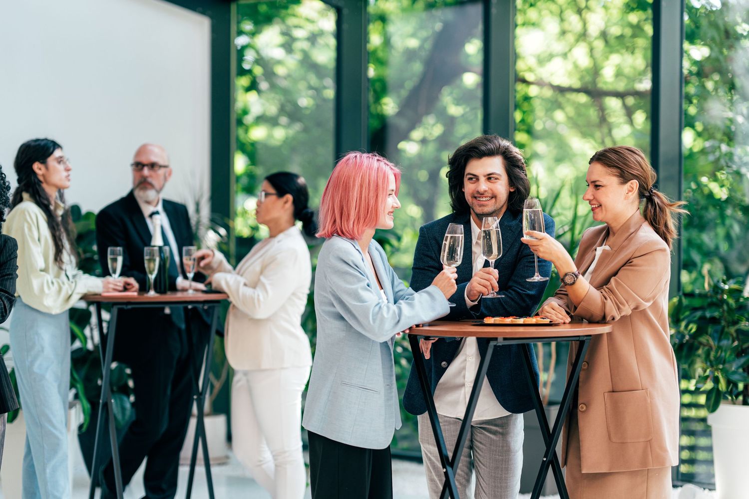 Business professionals networking and enjoying refreshments at a casual outdoor gathering.