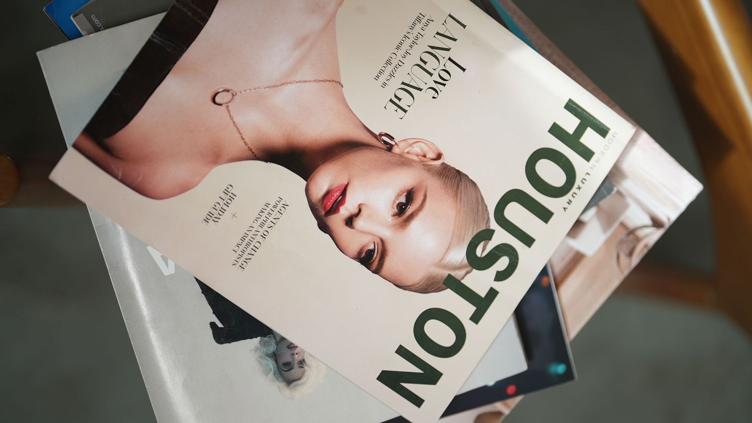 Fashion magazine cover displayed on white surface showing beauty editorial.