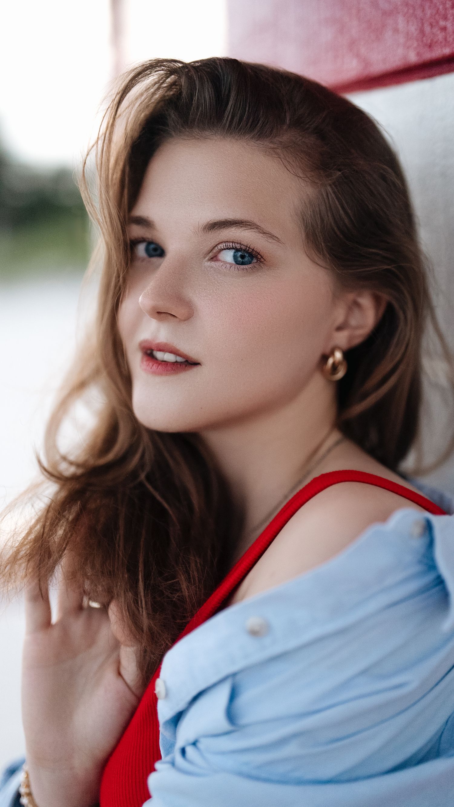 Portrait of someone in red and blue clothing against a light background.