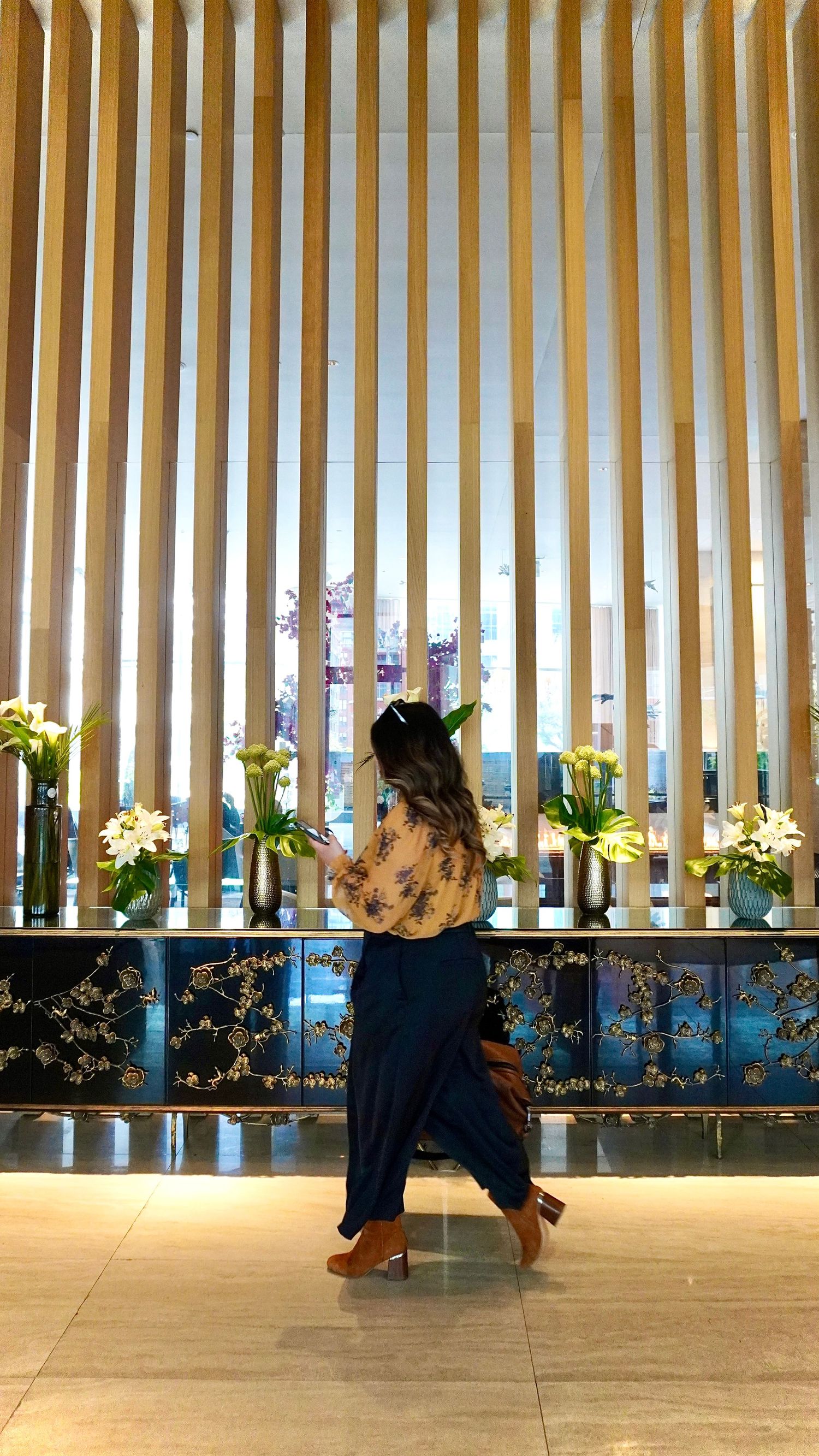 A series of four connected images showing people dancing in a modern space with vertical wooden slats and city views.