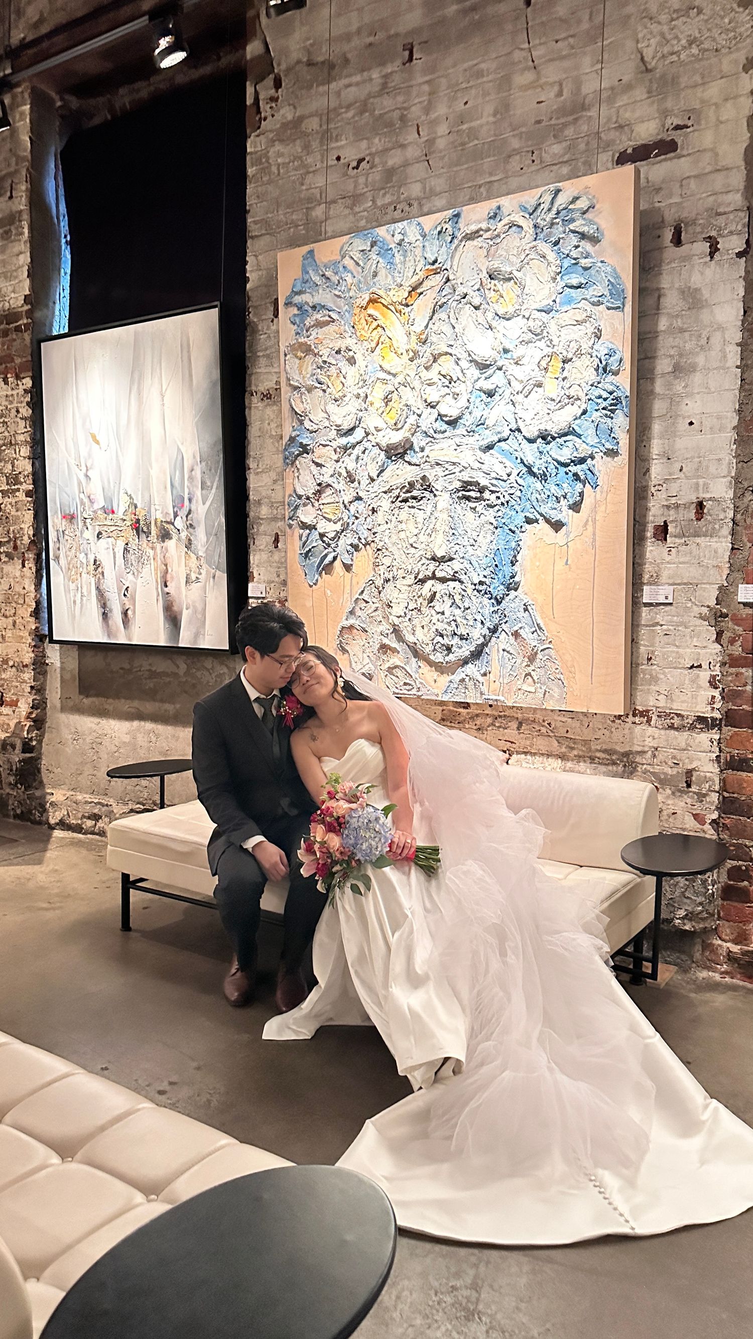 Wedding scene in industrial venue with modern art and exposed brick walls.