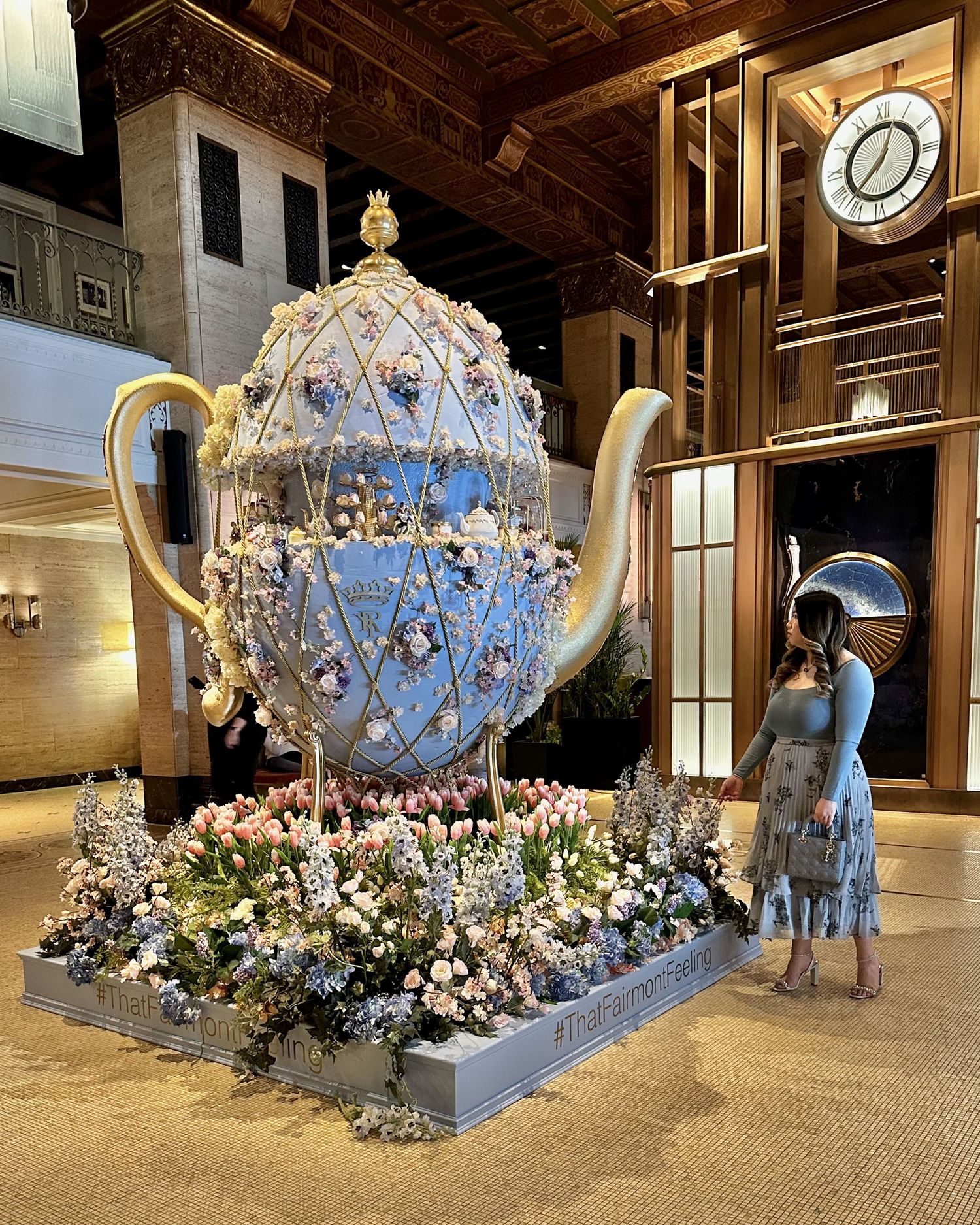 A luxurious crystal carriage display decorated with white floral arrangements and twinkling lights in an elegant venue.