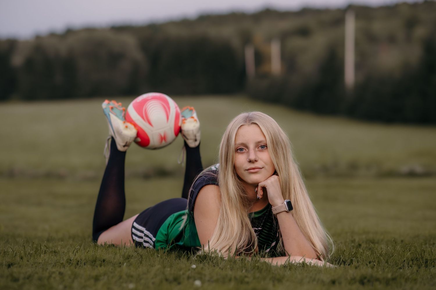 Athletic portrait on grass field with volleyball.