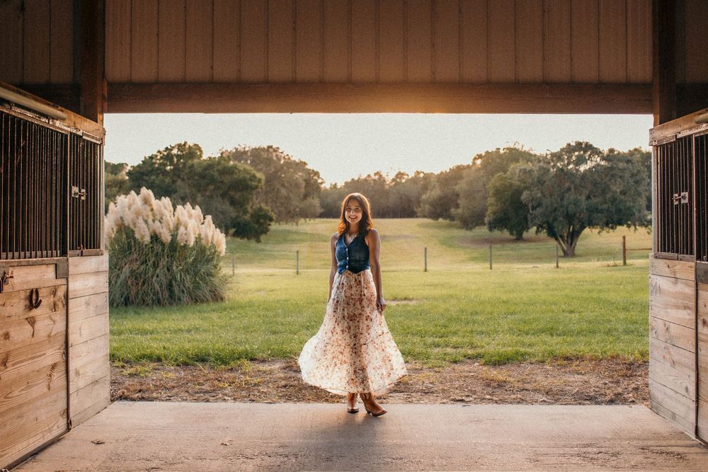 Country-style photo session at a rustic barn with wooden architecture and open fields.