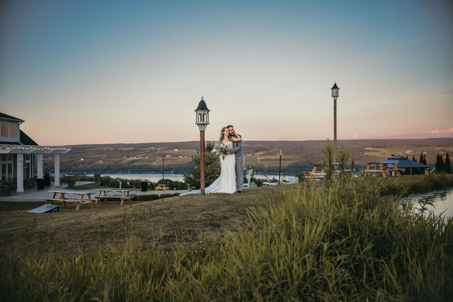 Panoramic landscape view with lamp posts and rolling hills at sunset.