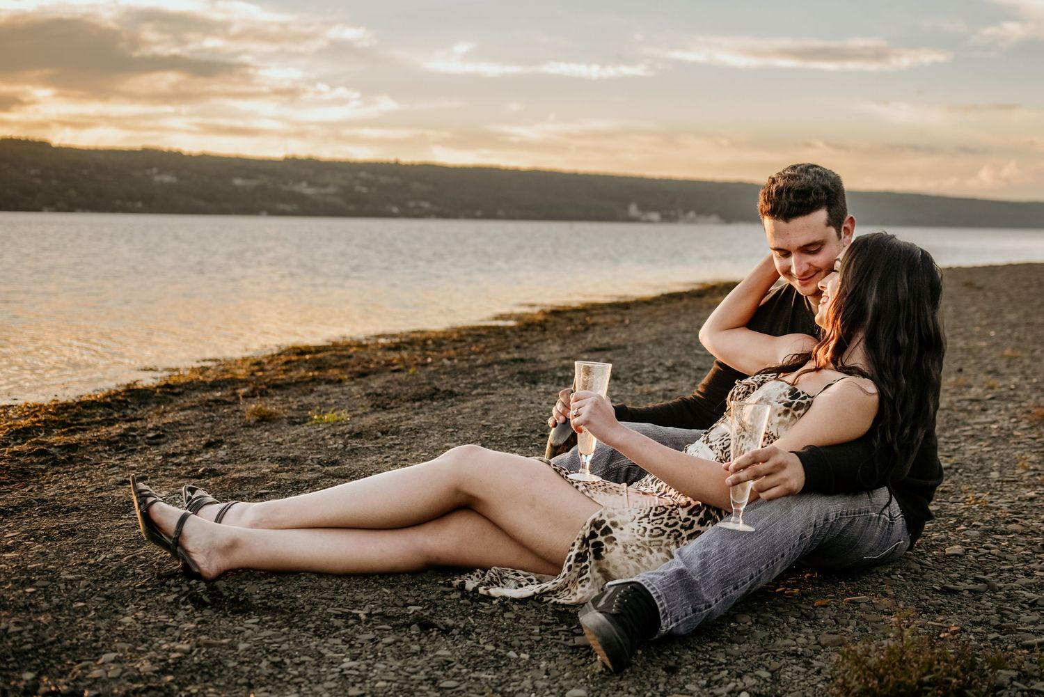 Couple relaxing together on blanket during golden hour outdoor photography session.