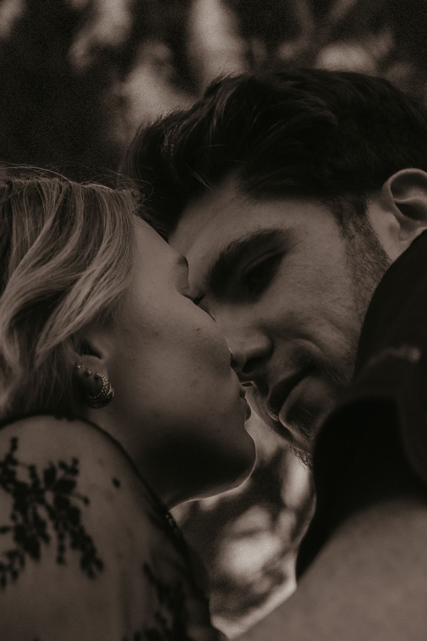 A romantic black and white photo series showing intimate close-up moments between a couple sharing tender kisses.