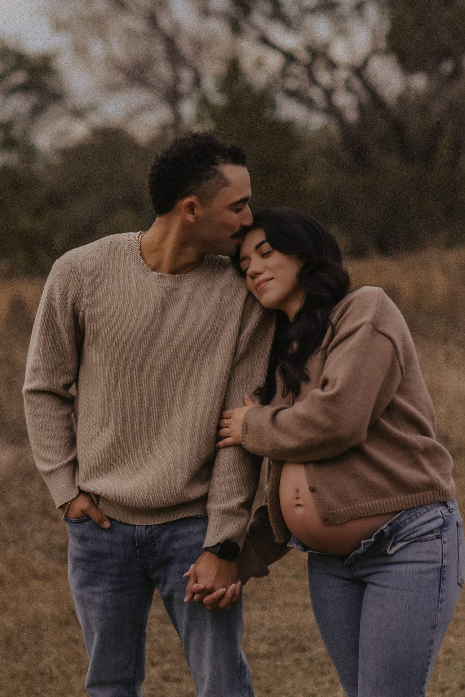 A romantic couple in matching beige sweaters share tender moments in a series of intimate outdoor photos.