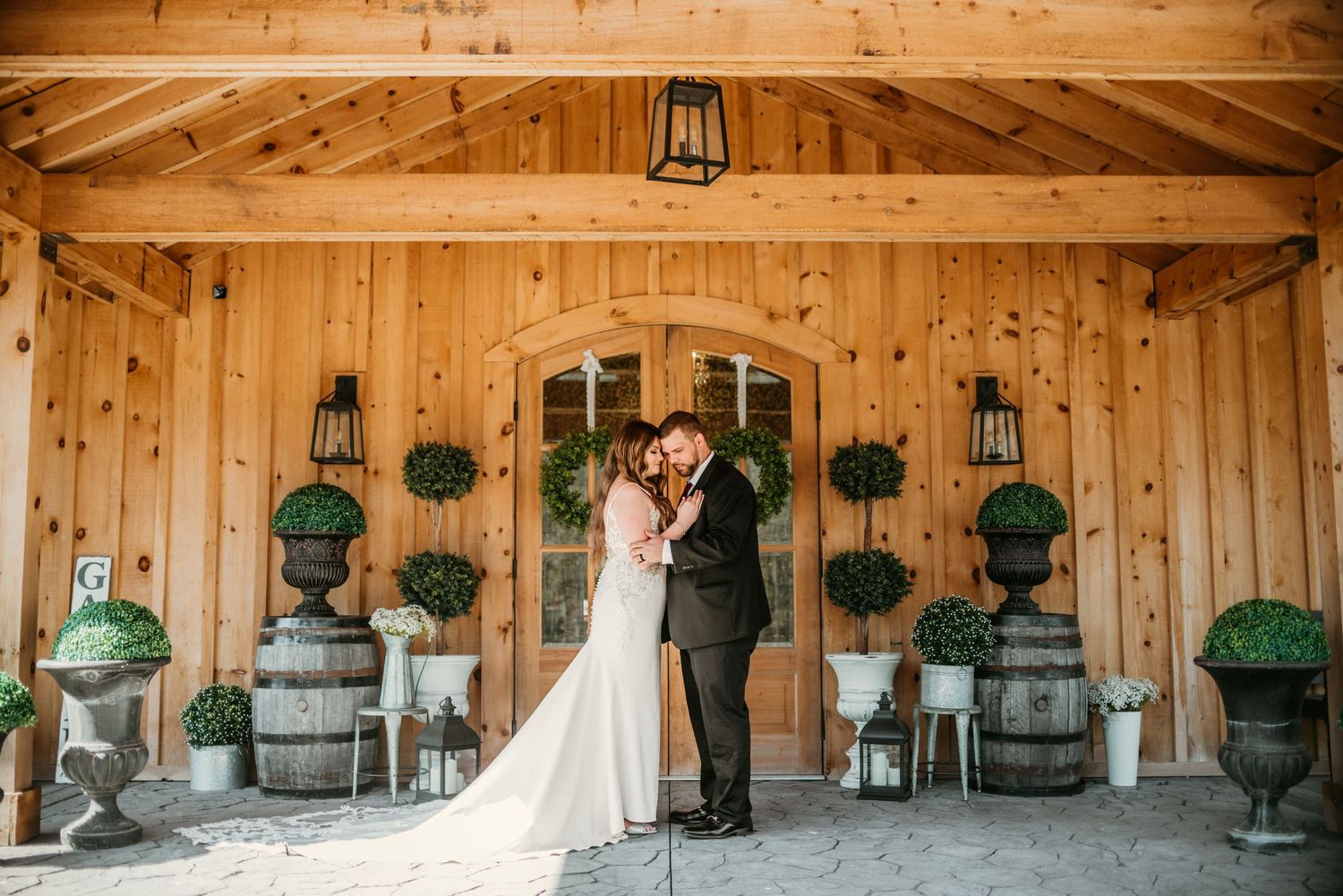 Rustic wooden barn interior with hanging lanterns and decorative planters.