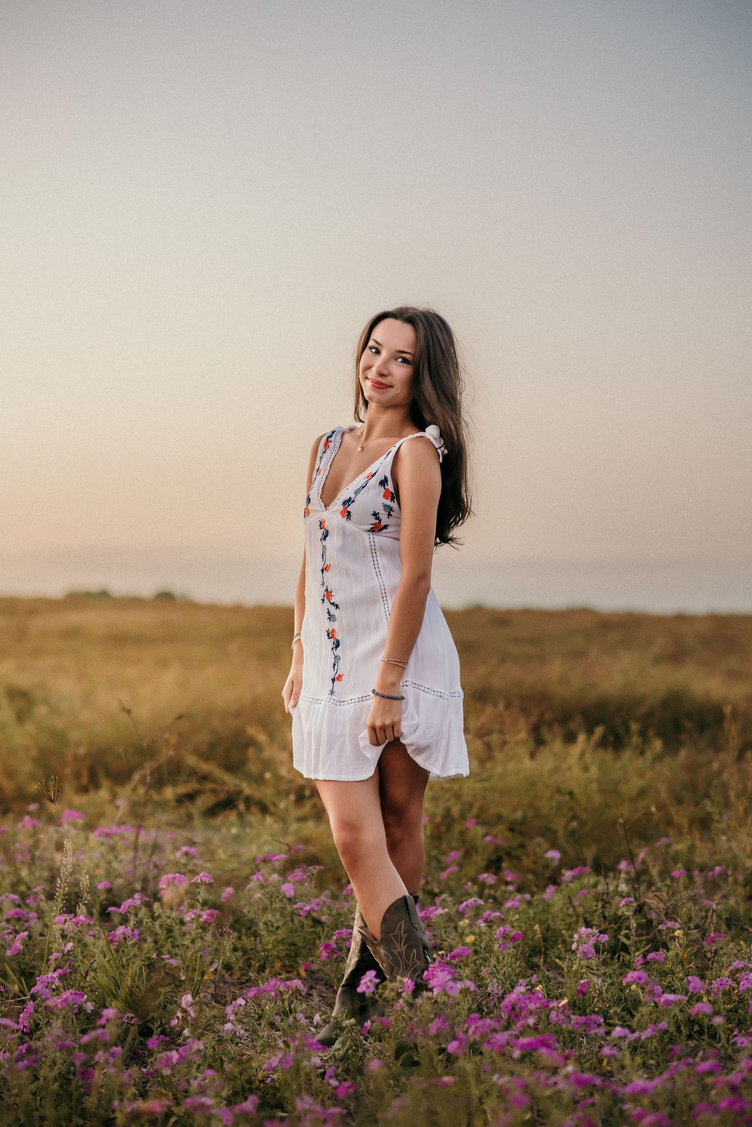 Romantic portrait session in field of purple wildflowers during sunset.