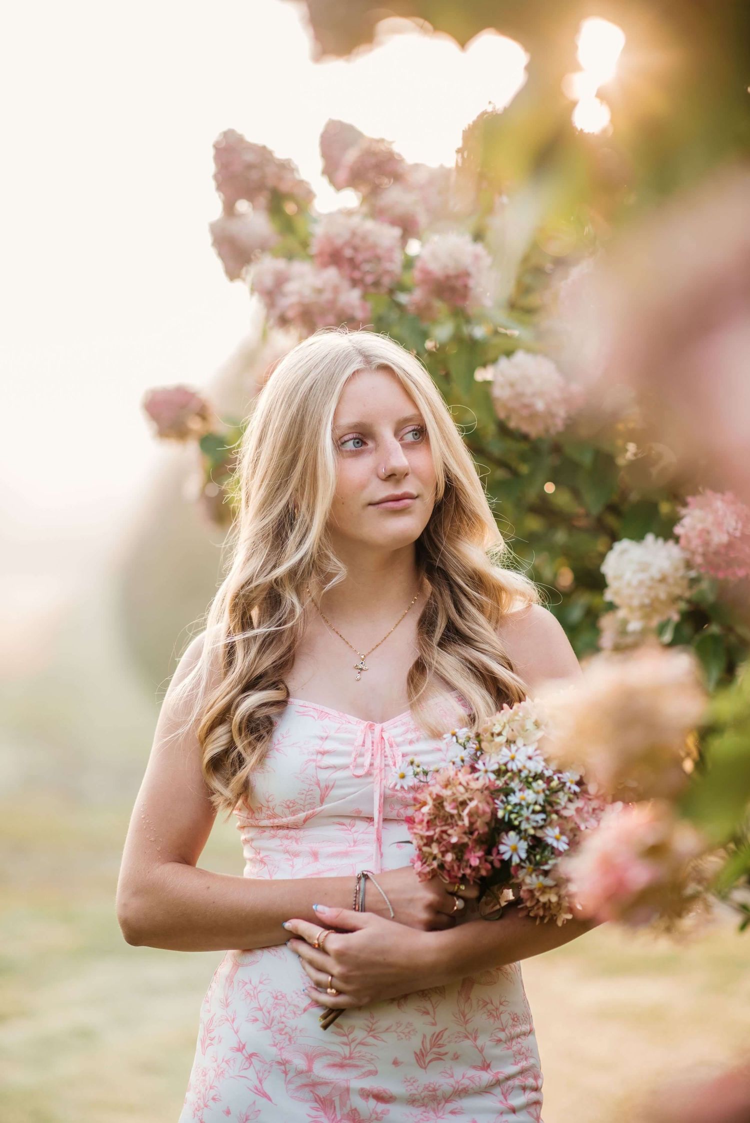 Pink floral garden with blooming roses in soft golden sunlight.