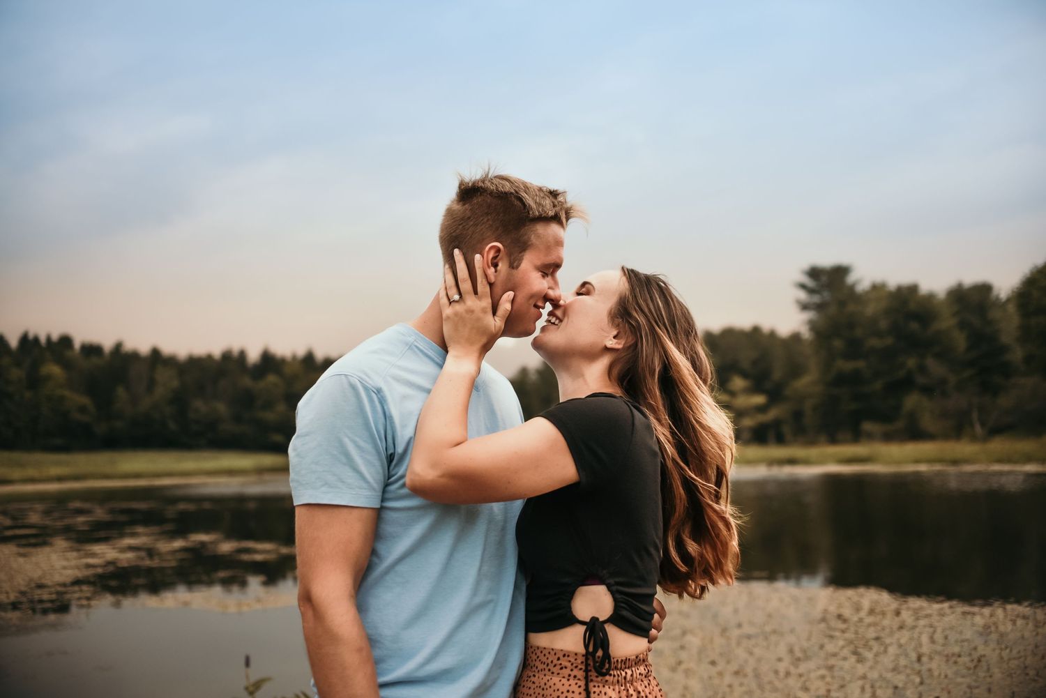 Intimate couple's photoshoot at sunset by a scenic lakeside location.