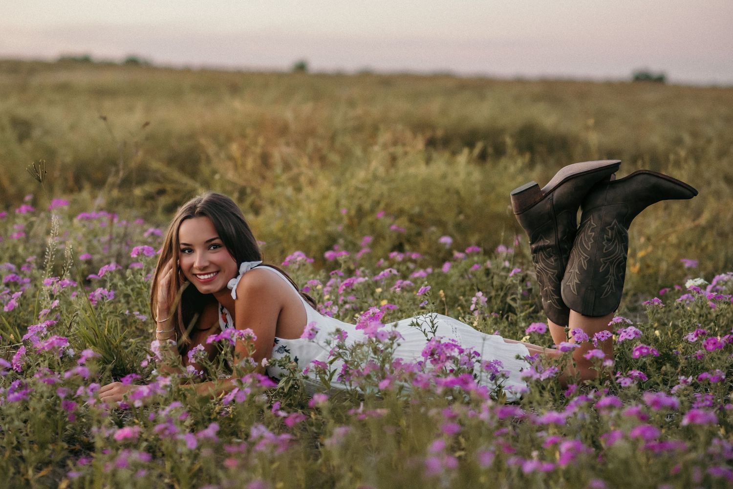 Natural light portrait session in blooming meadow with sunset glow.