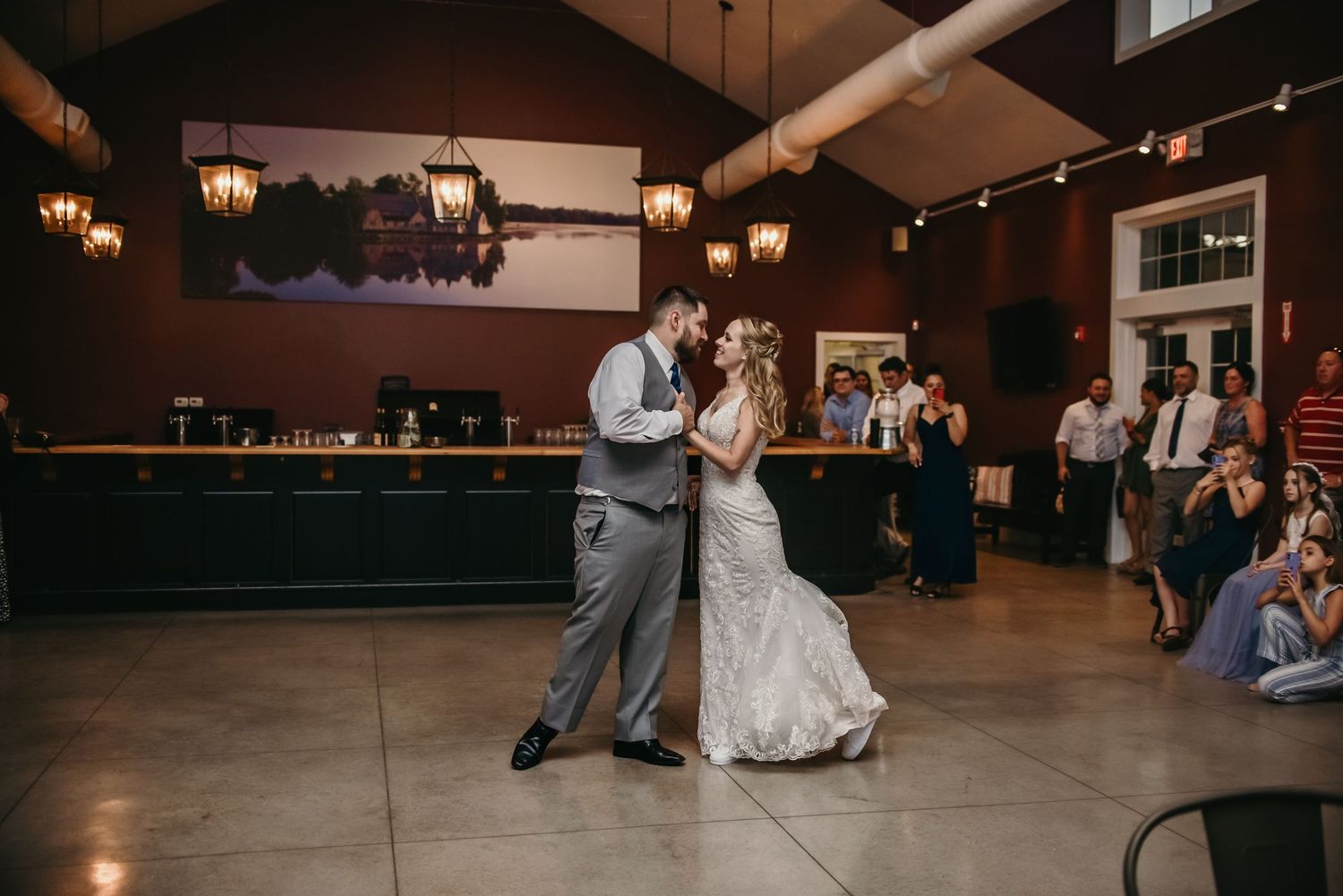 Wedding reception dance floor with dim lighting and guests celebrating.