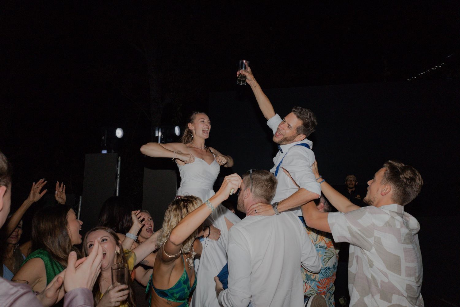 Bride and Groom being held in the air by their friends to celebrate their union