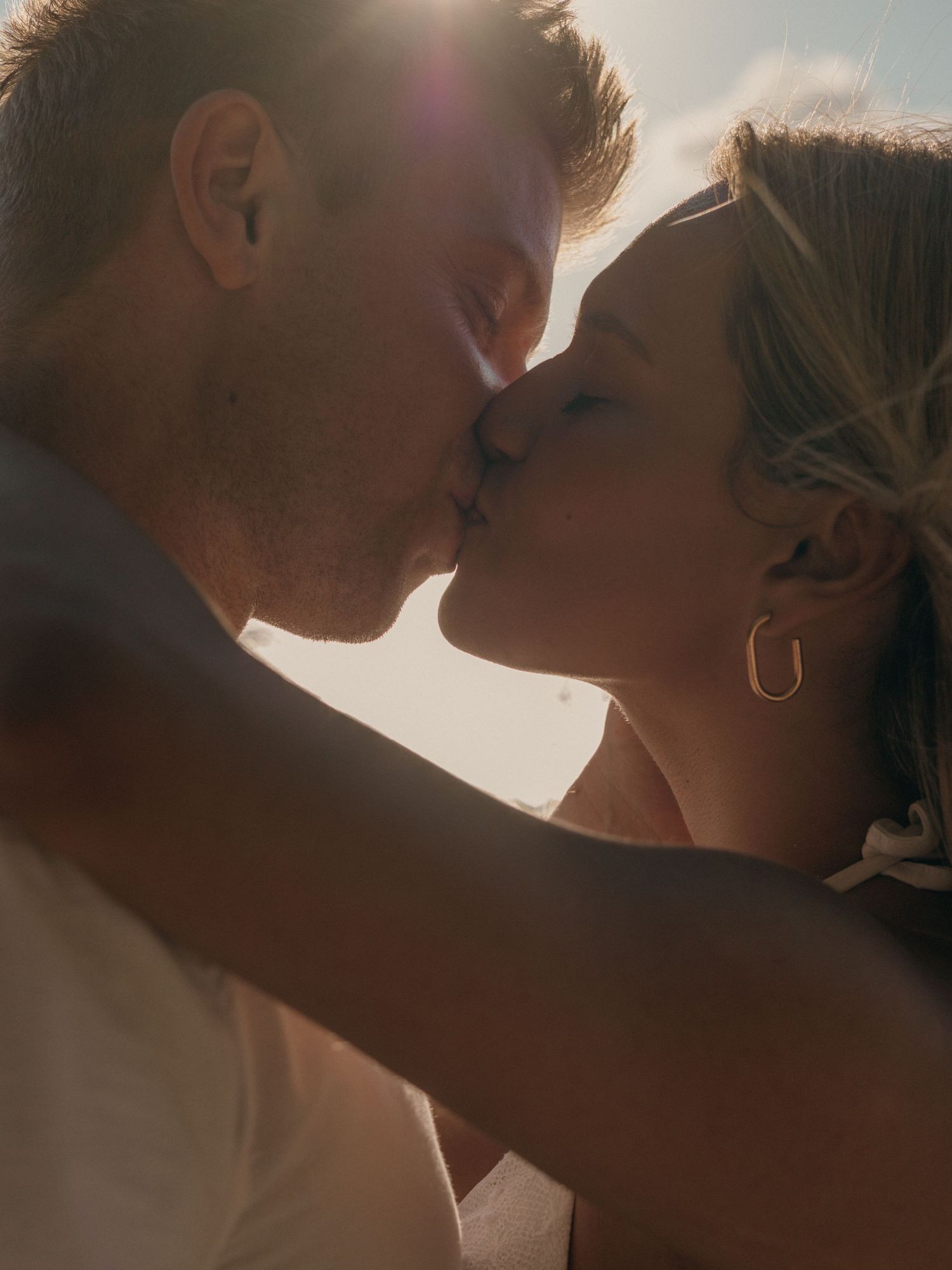 Photo by Bendito Recuerdo in Costa Rica, close up view of a couple kissing with the sun in the back.