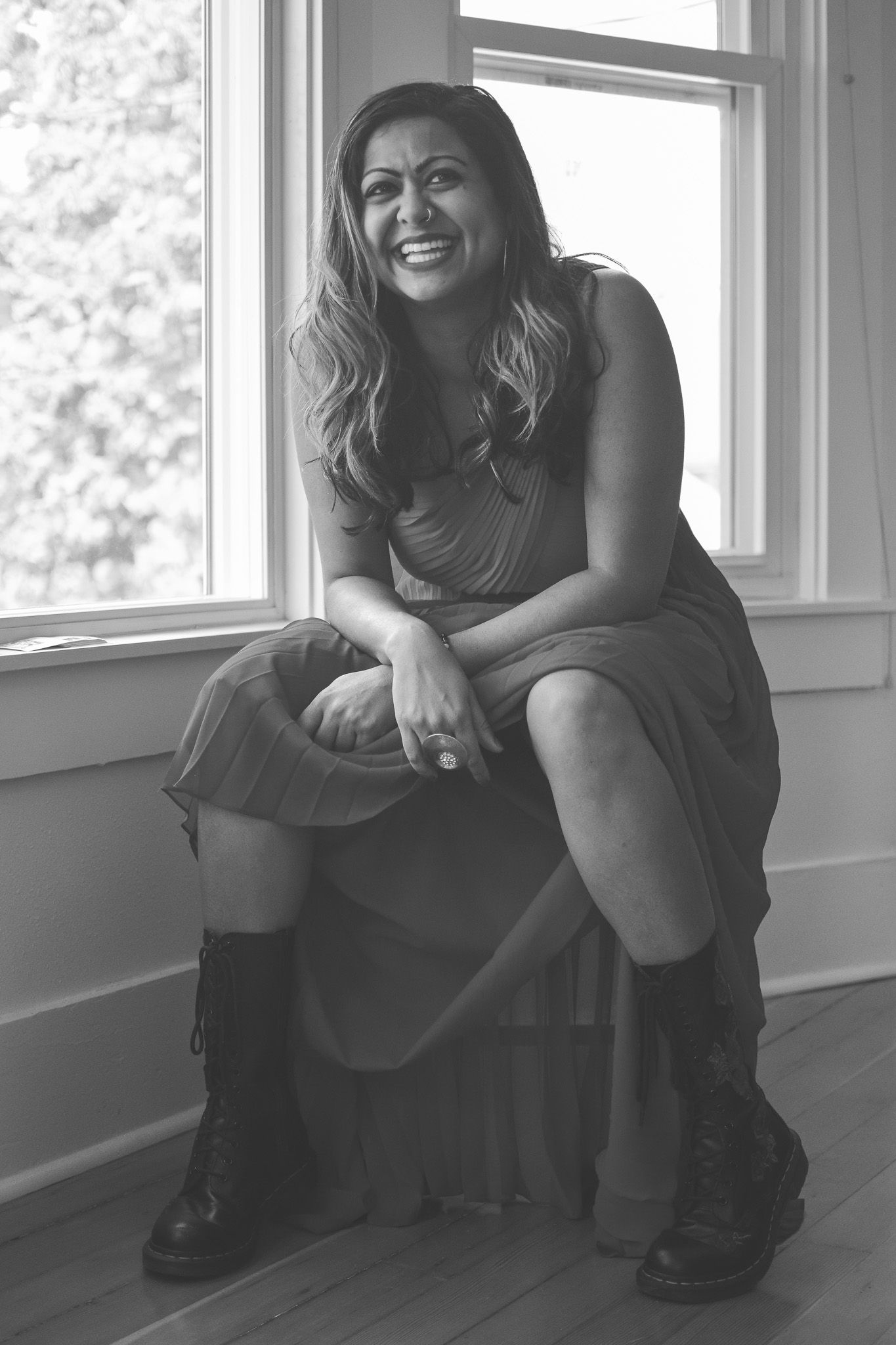Black and white portrait in a bright room with natural window light.