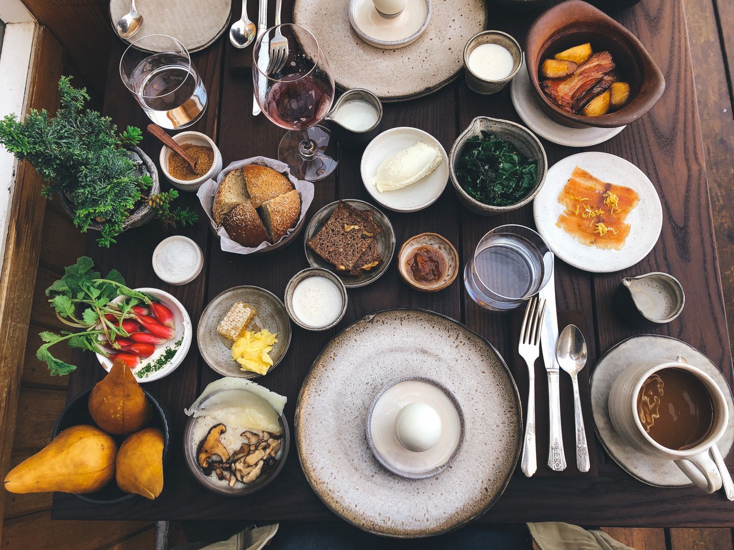 Overhead view of a rustic table setting with various dishes and condiments spread out.