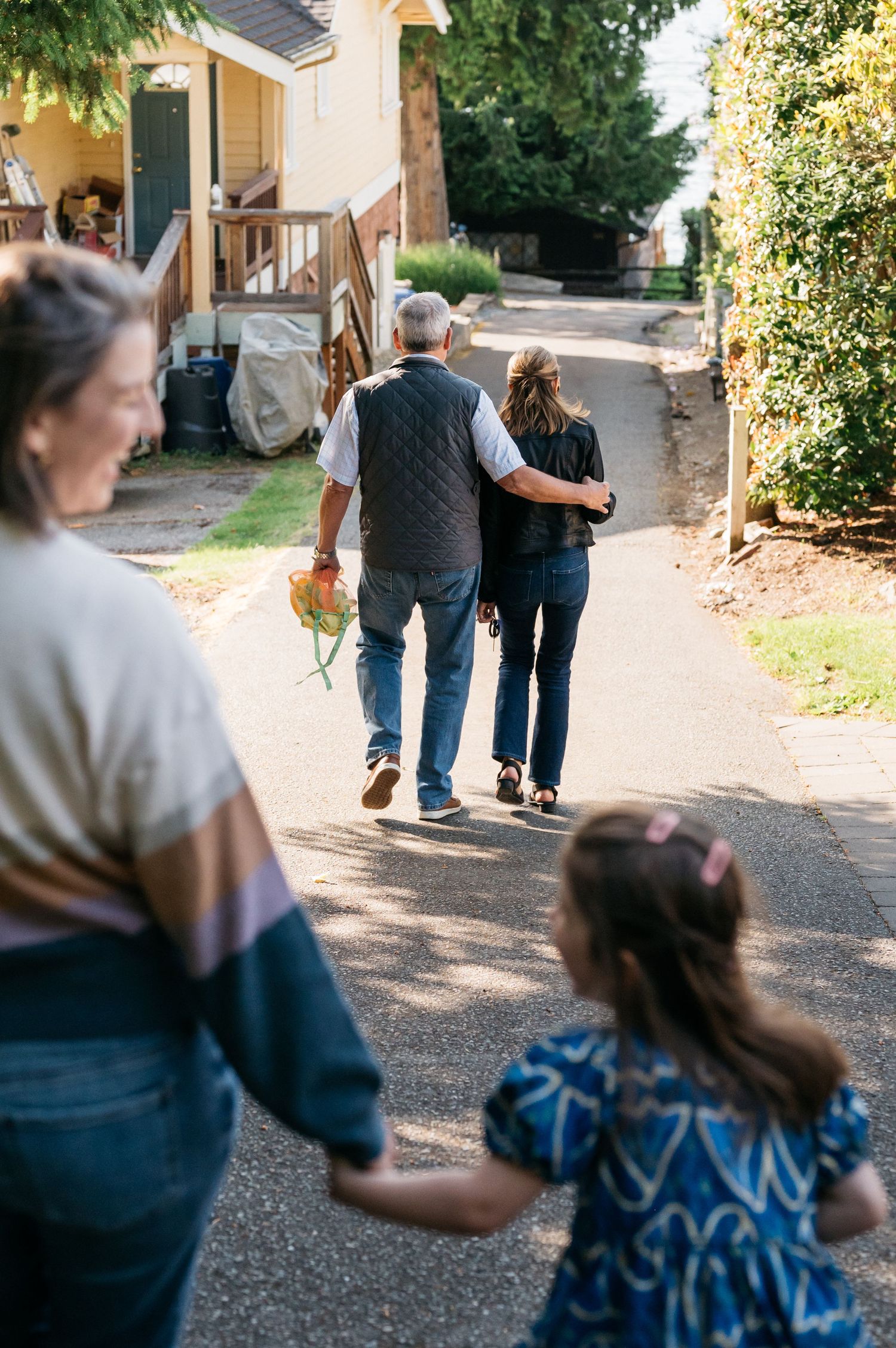 People walking together on a gravel path near buildings.