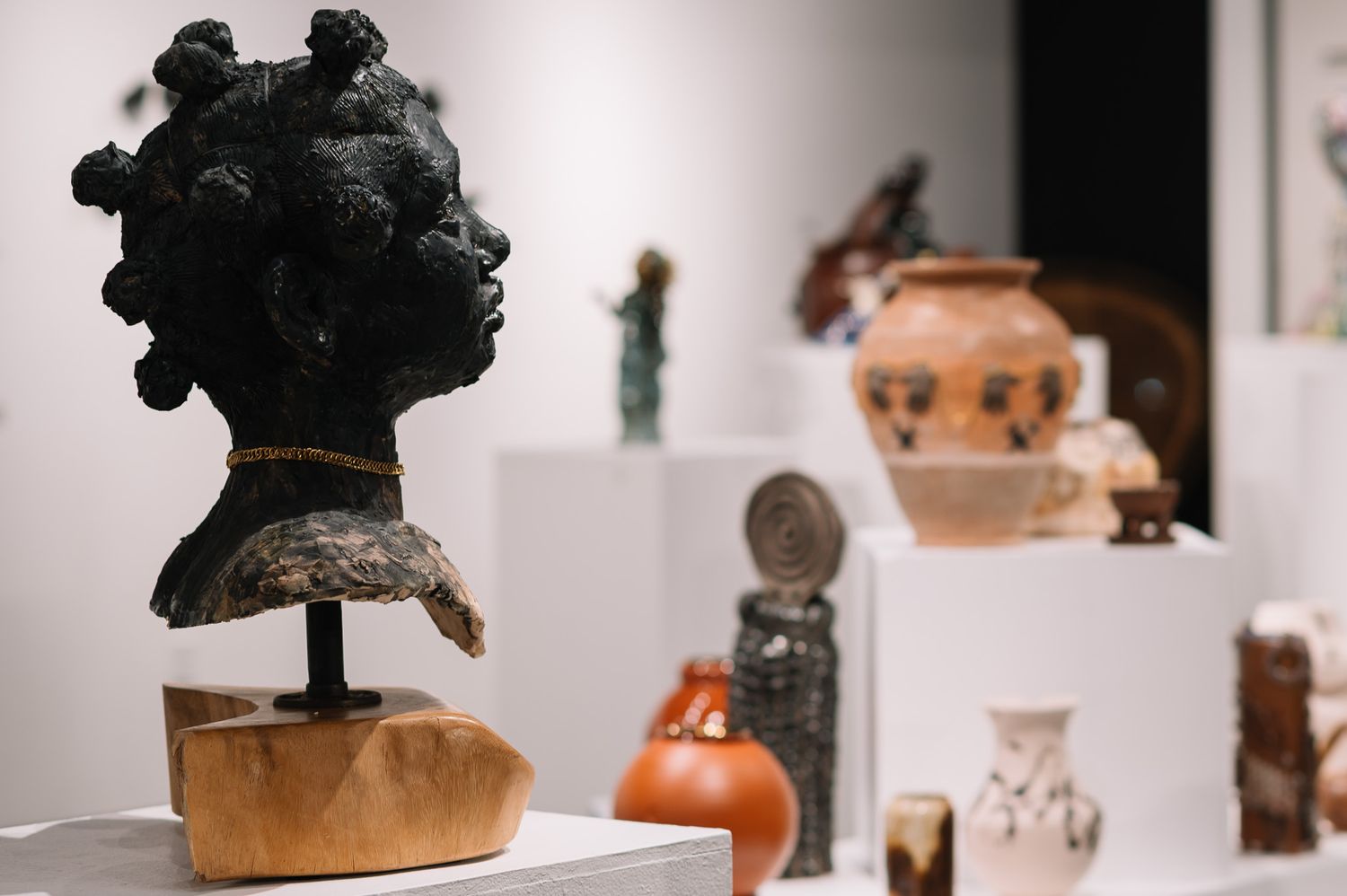 Display of antique black hats and accessories in a museum or gallery setting.