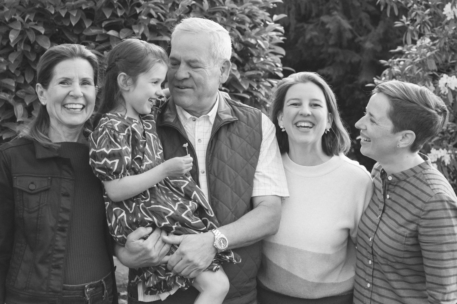 Black and white family portrait showing joyful laughter and connection between generations.