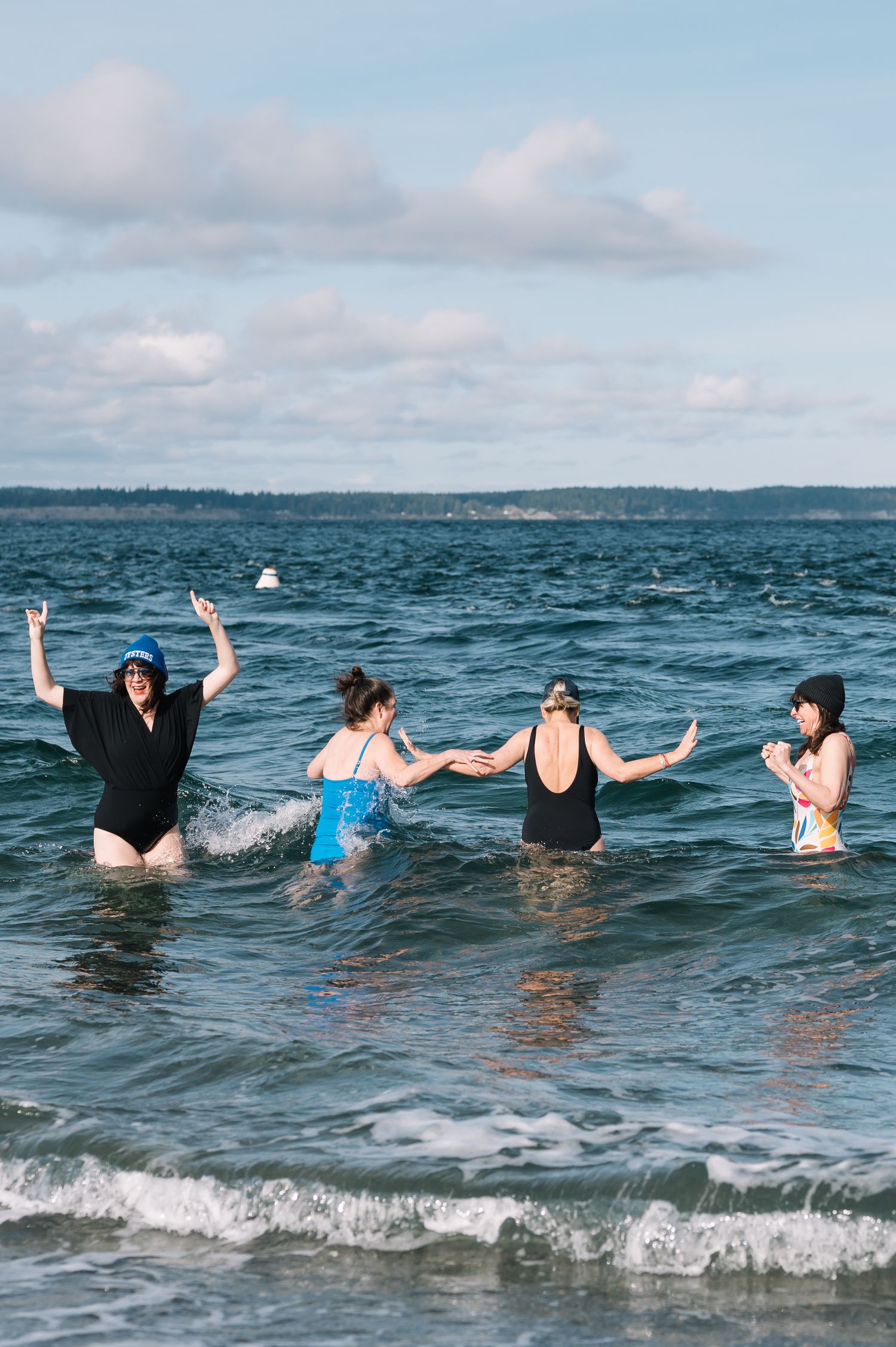 Group of swimmers enjoying the ocean waves on a cloudy day.